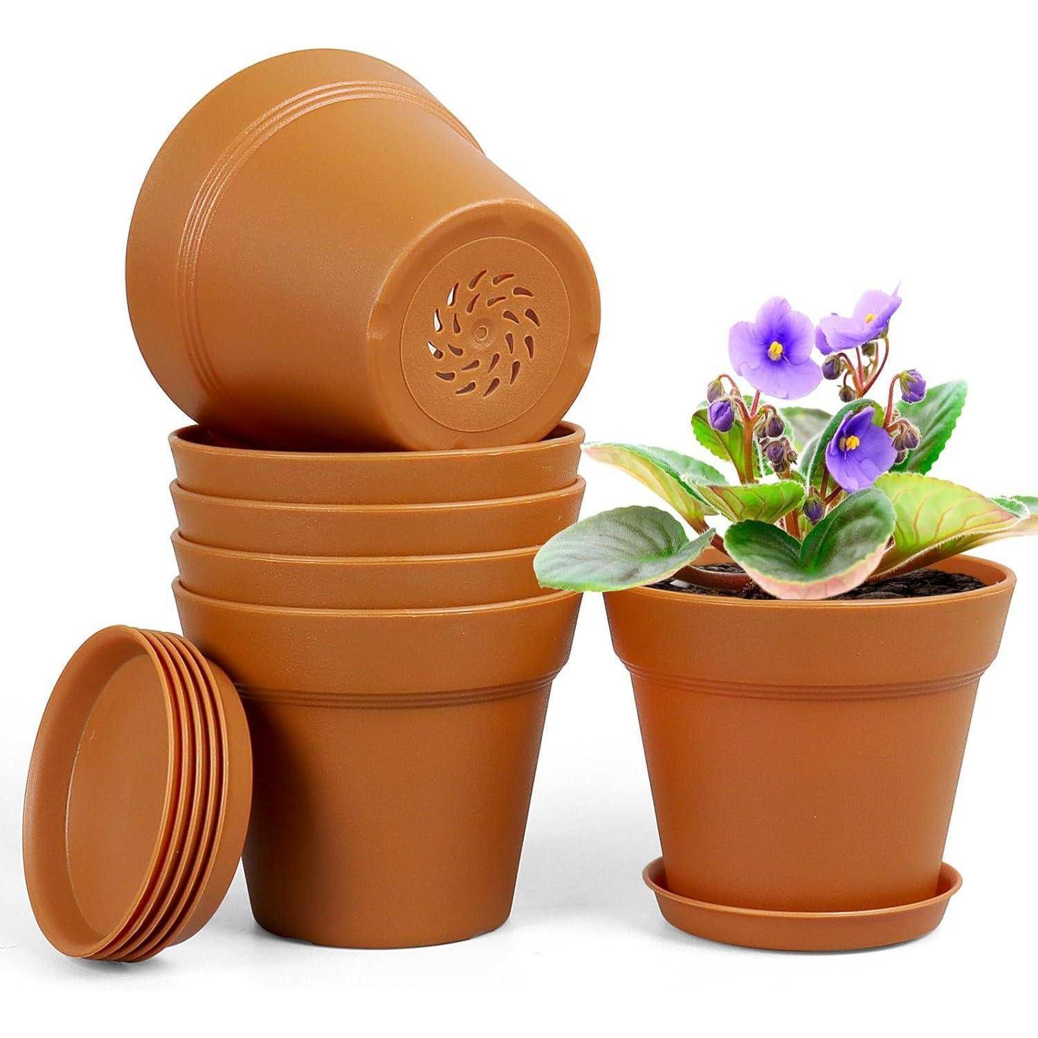 Stapel von braunen Plastikblumentöpfen neben einem Topf mit blühenden violetten Blumen, wobei der Gartenaufbau hervorgehoben wird.