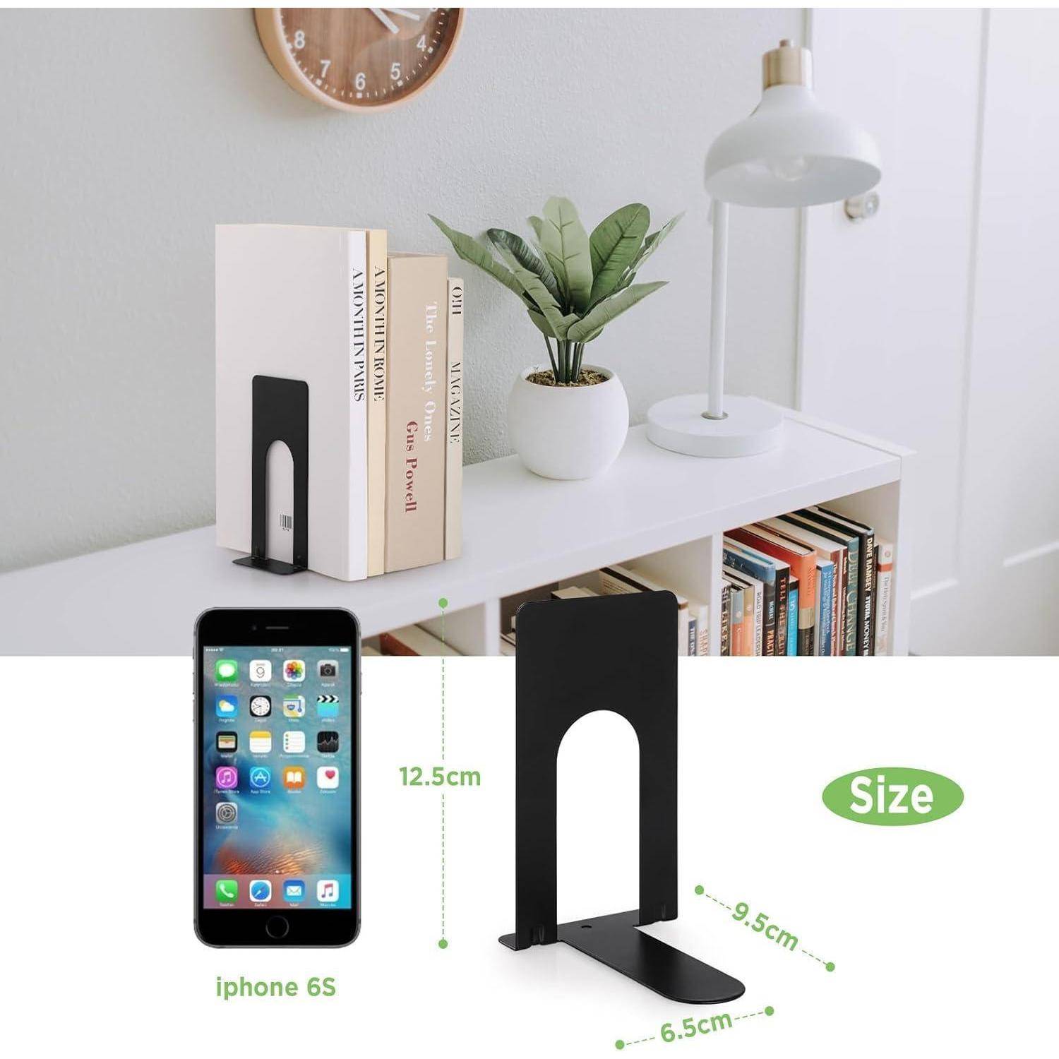 Ein schwarzer Metall-Buchstütze, die Bücher auf einem weißen Regal neben einer Topfpflanze und einer Lampe stützt. Das Bild zeigt einen Größenvergleich mit einem iPhone 6s.