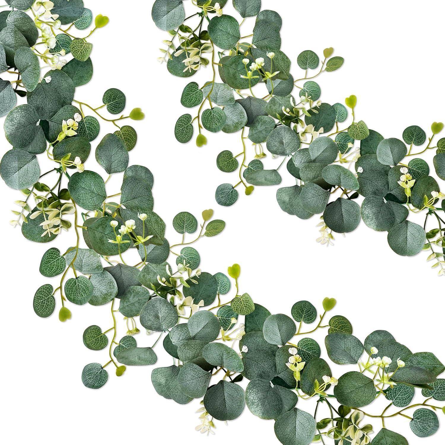 Eine dekorative Anordnung von Eukalyptusblättern und kleinen weißen Blüten auf einem weißen Hintergrund, die ein geschwungenes, fließendes Muster bildet.