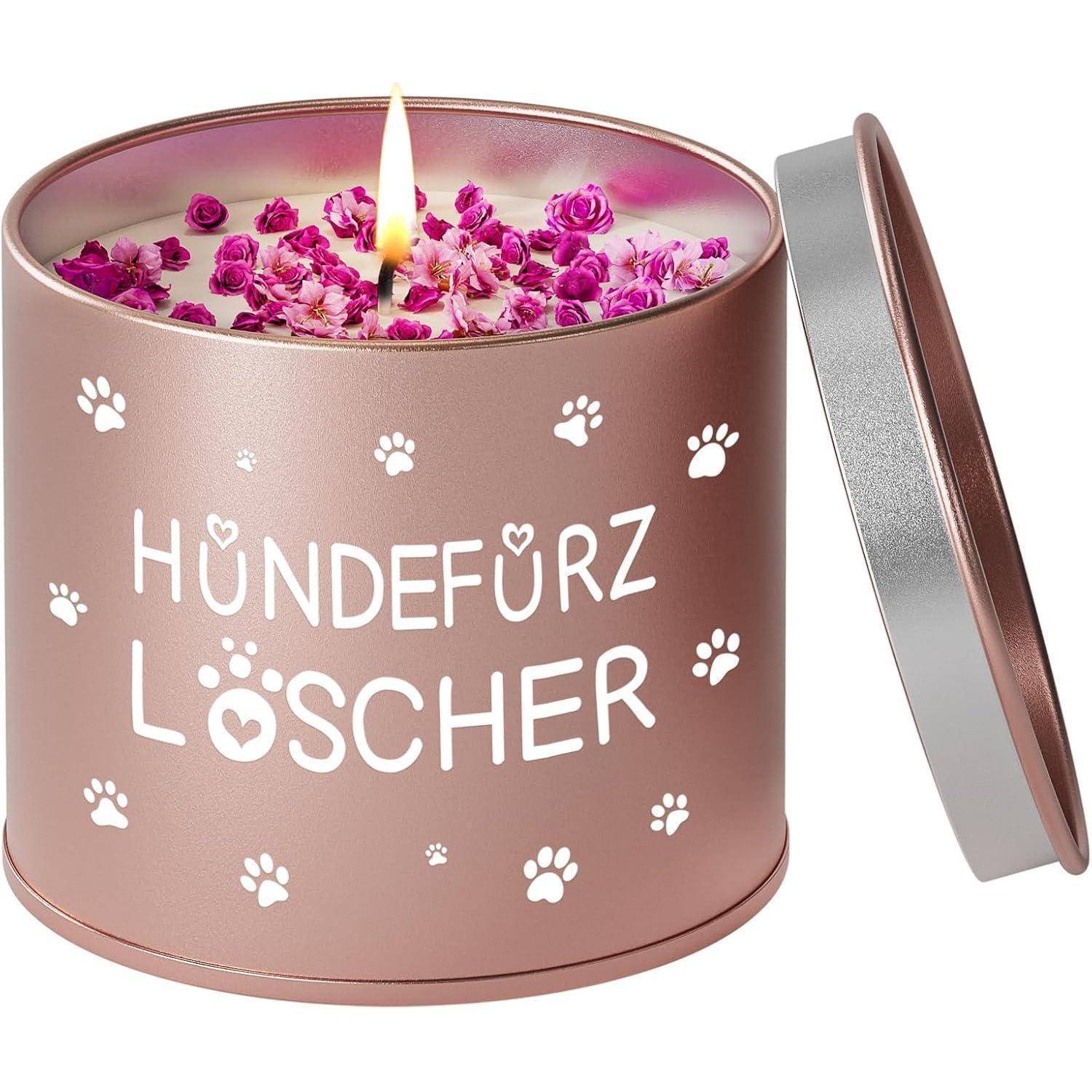 Eine brennende Kerze in einer roséfarbenen Blechdose mit der Aufschrift 'HUNDEFÜRZ LÖSCHER', umgeben von rosa Rosenblüten und Pfotenabdrücken.