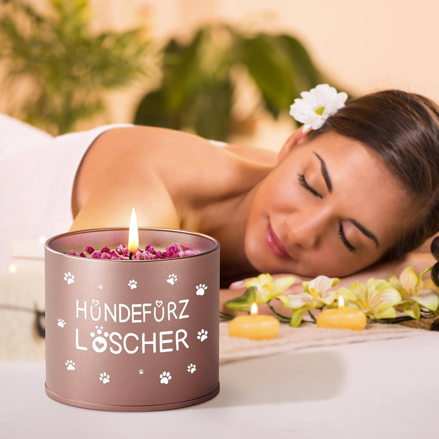 Eine entspannte Frau liegt während einer Spa-Behandlung auf dem Bauch, mit einer entzündeten 'Hundefurz Löscher' Kerze mit Pfotenabdrücken daneben.