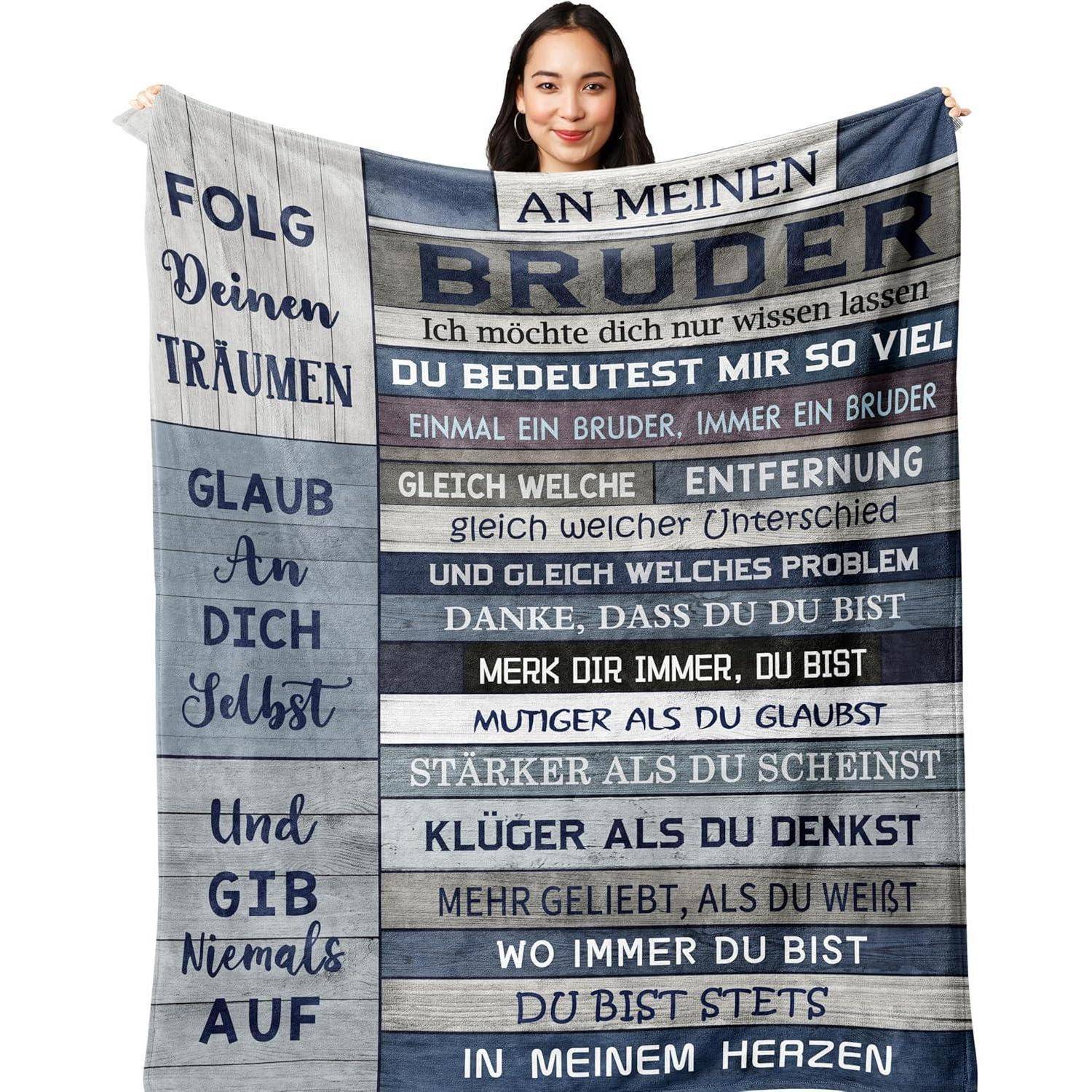 Eine Person hält eine Decke mit deutschem Text, der Wertschätzung und inspirierende Zitate über einen Bruder ausdrückt und Stärke sowie Glauben betont.