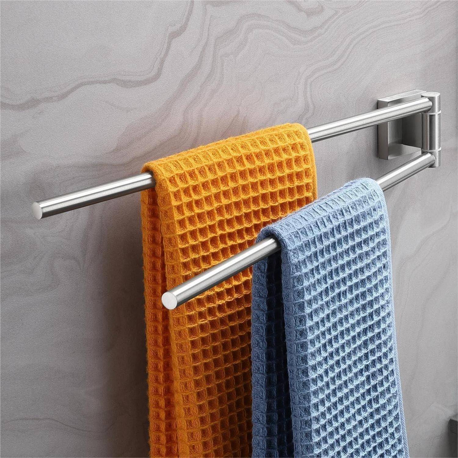 Ein orangefarbenes und ein blaues Handtuch hängen an einer silbernen Handtuchstange vor einer beigen, gemusterten Wand.