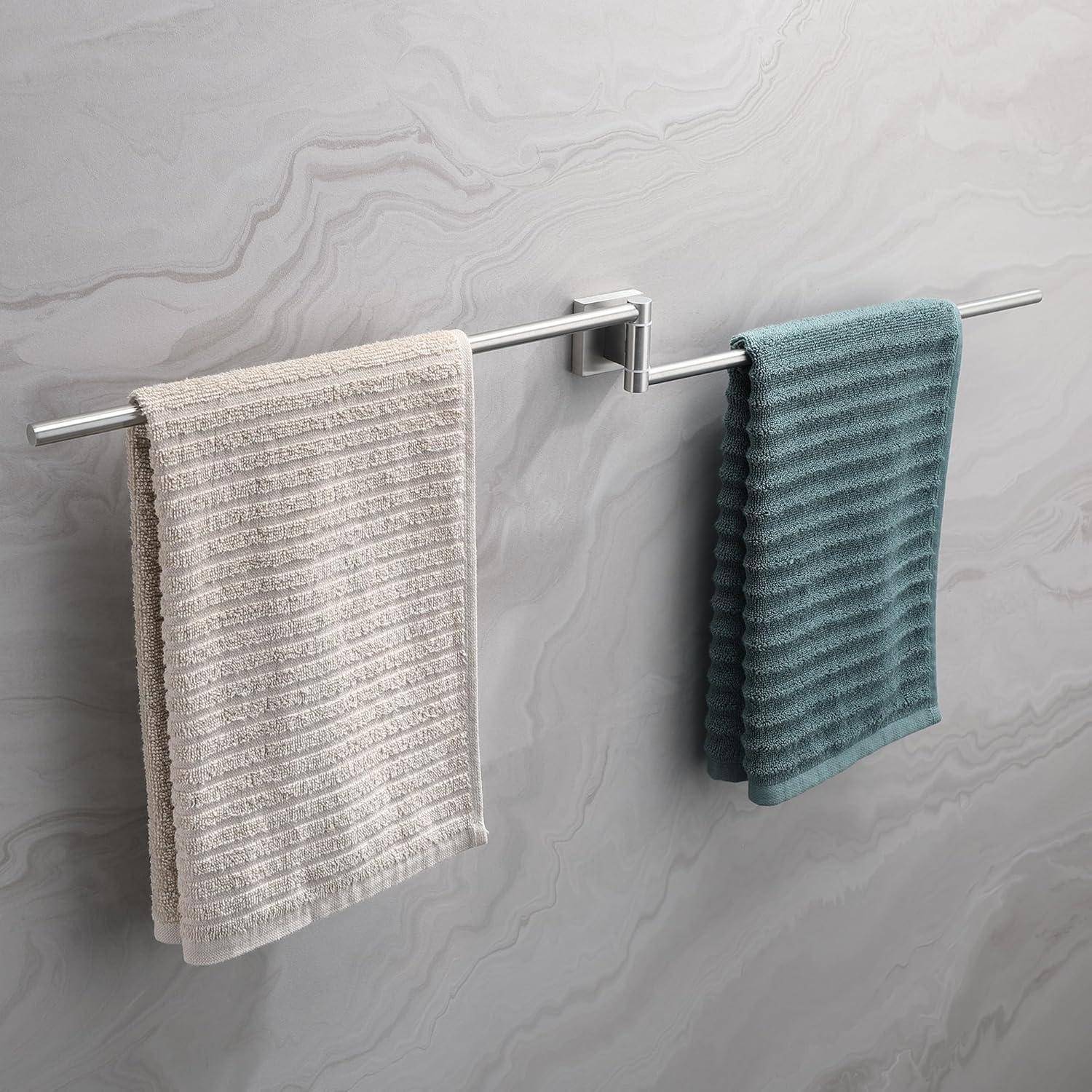 Zwei Handtücher hängen an einer Metallstange vor einer marmorierten Wand, wobei ein Handtuch in Beige und das andere in Petrolblau gehalten ist und damit ein minimalistisches Badezimmerdesign unterstreicht.