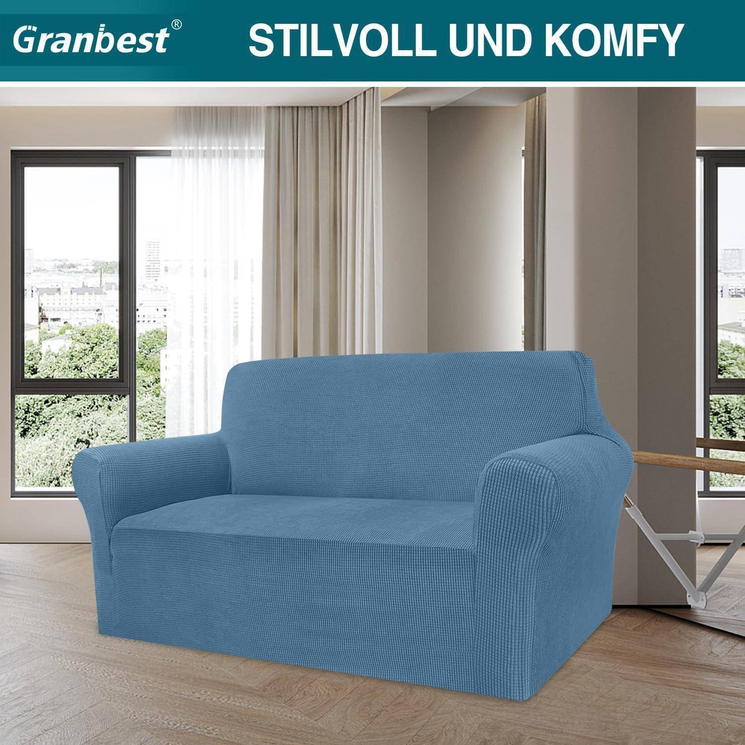 Ein modernes Wohnzimmer mit großen Fenstern und einem blauen Sofa, das mit einem Stoffbezug überzogen ist, mit den Worten 