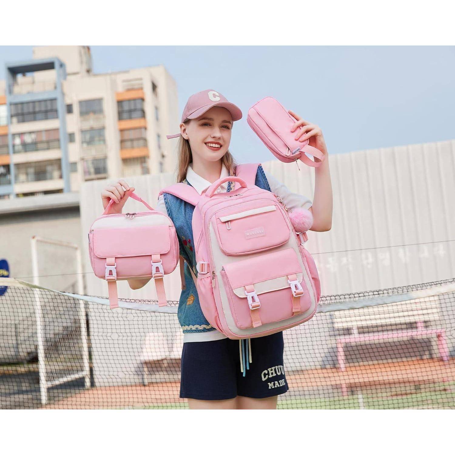 Eine Person lächelt und hält einen rosa Rucksack, eine Handtasche und ein Federmäppchen. Sie steht im Freien in der Nähe eines Tennisplatzes und trägt lässige Kleidung.