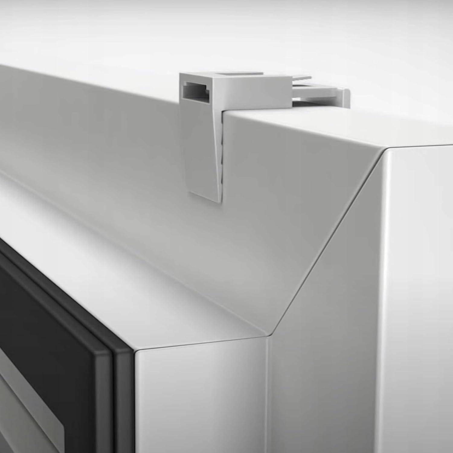 Eine Klemme sichert die obere Ecke eines weißen rechteckigen Objekts, höchstwahrscheinlich einer Platte oder eines Geräts, vor einem Hintergrund aus ähnlichem Material.