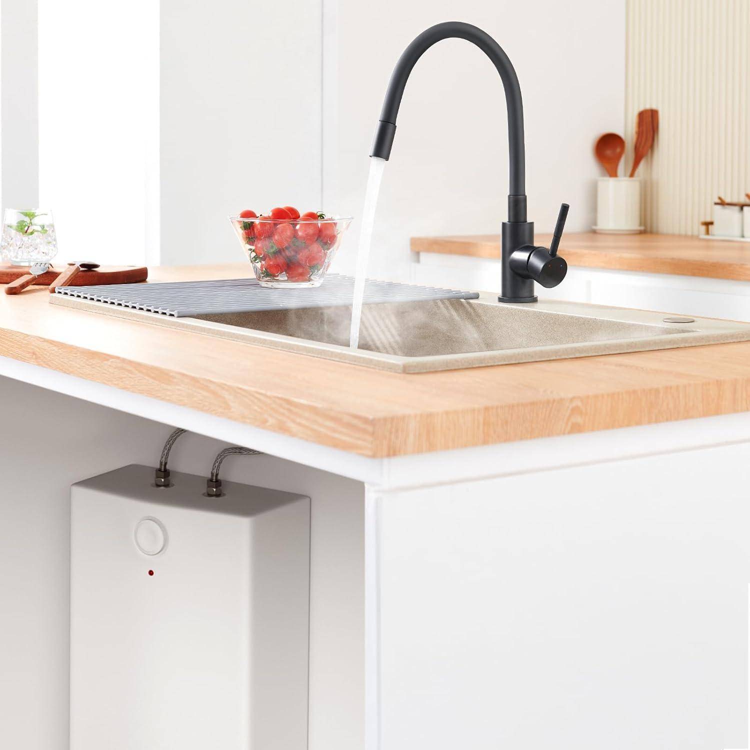 Ein Küchenwaschbecken mit einem schwarzen Wasserhahn, der Wasser in ein Edelstahlbecken gießt; eine Schüssel mit Erdbeeren und Besteck liegen auf der Arbeitsplatte.