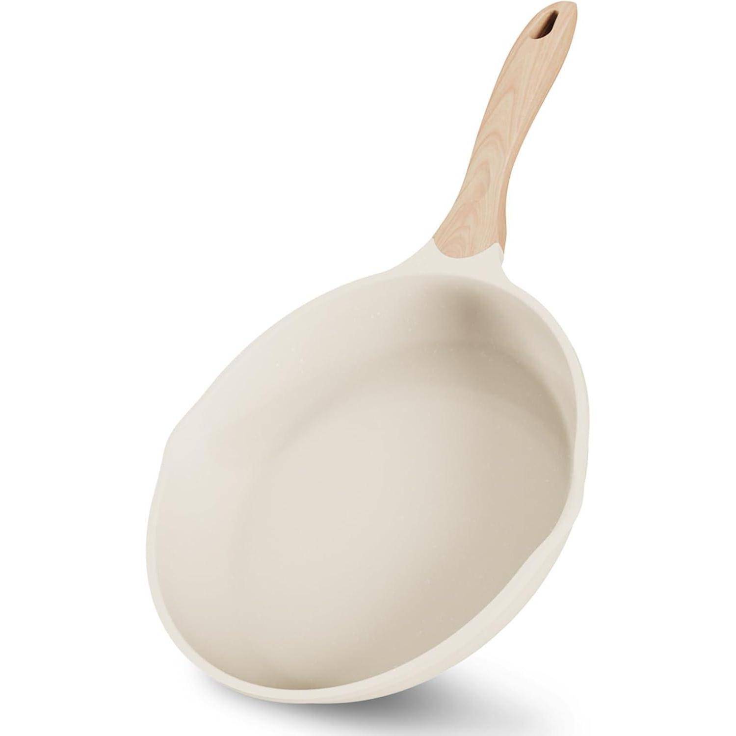 Eine weiße Bratpfanne mit einem hellen Holzgriff, von der Seite betrachtet.