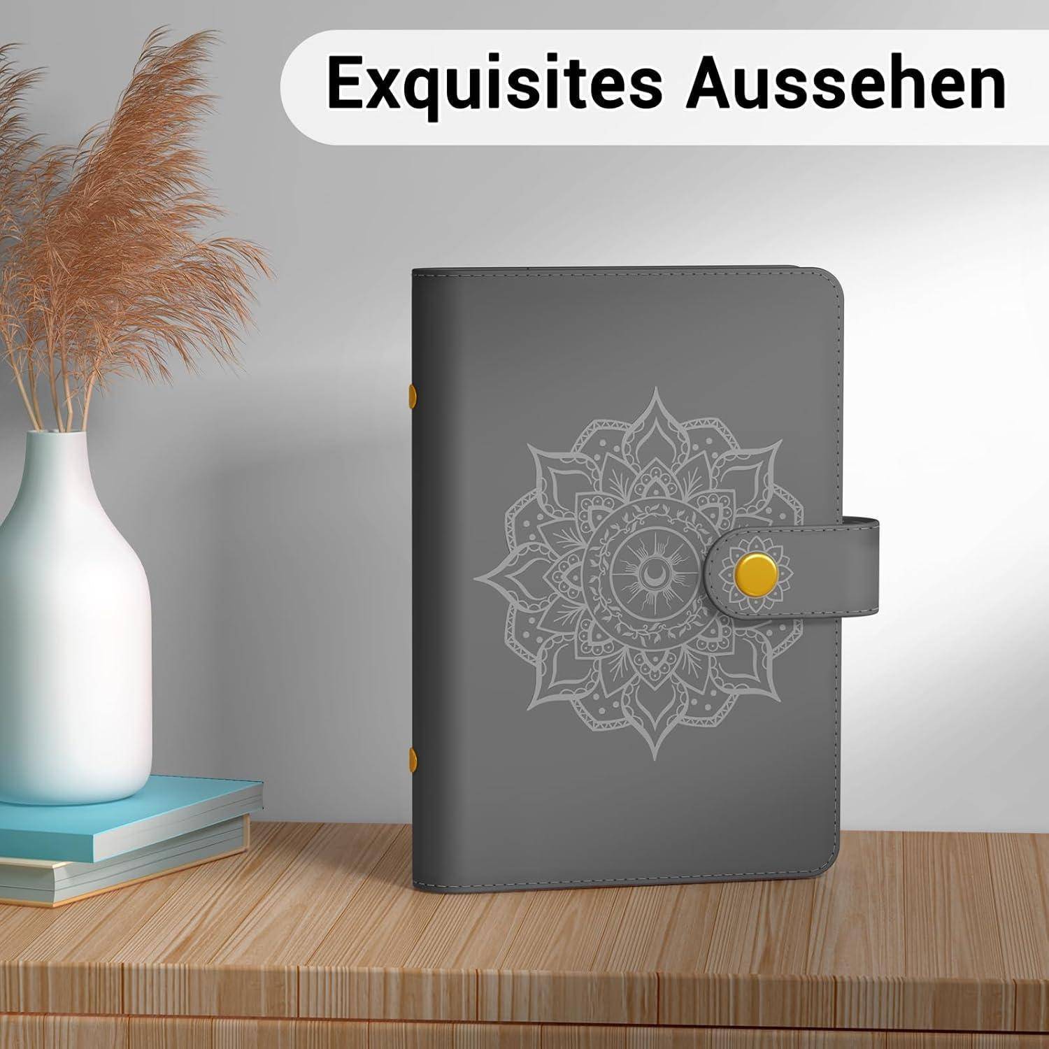 Ein stilvoller grauer Notizblock mit einem dekorativen Mandala auf dem Einband liegt auf einer Holzoberfläche neben einer Vase mit getrockneten Blumen. Text lautet 'Exquisites Aussehen'.