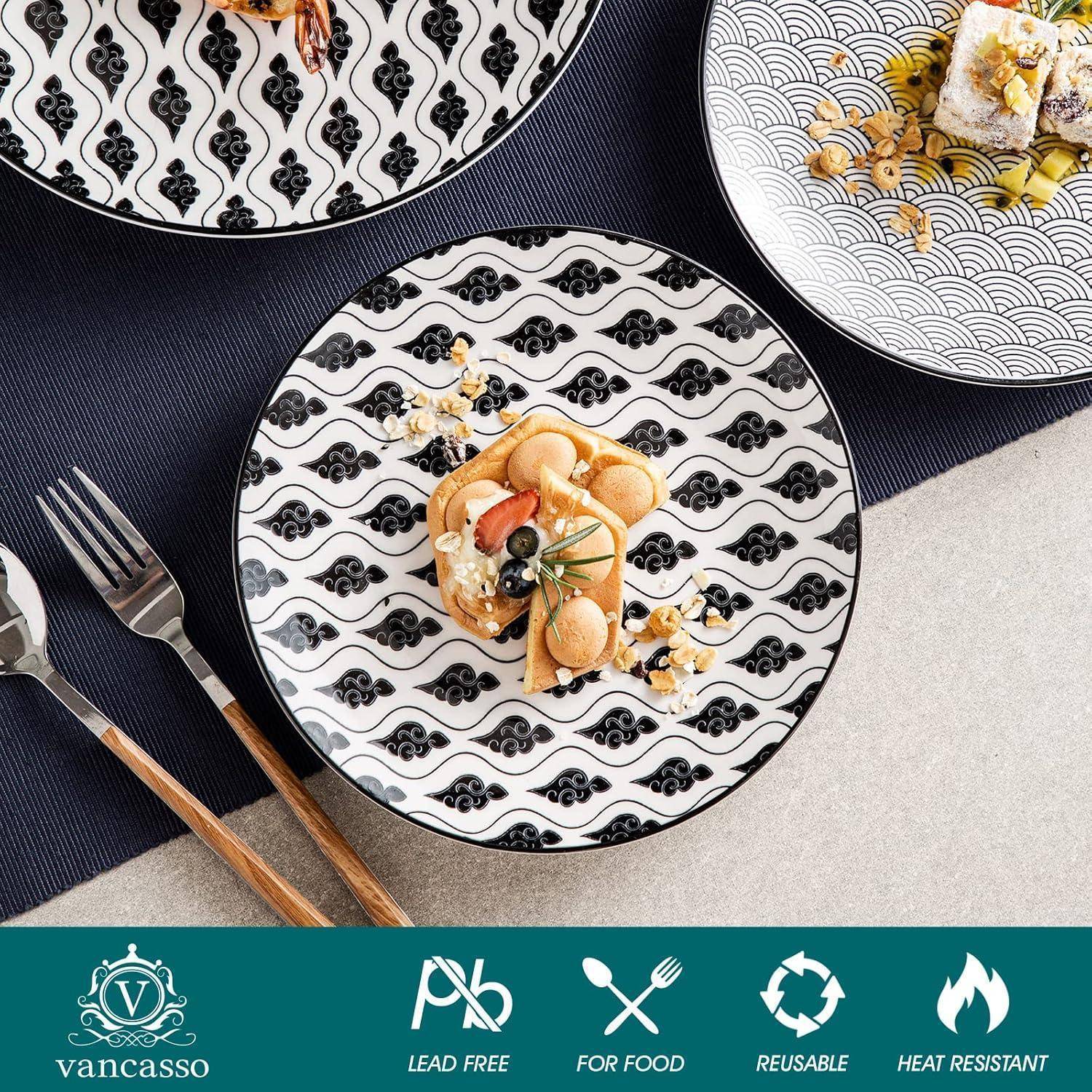 Ein Set aus drei dekorativen Tellern, jeder mit charakteristischen schwarz-weißen Mustern, angeordnet auf einem Tisch mit Essen und Besteck.