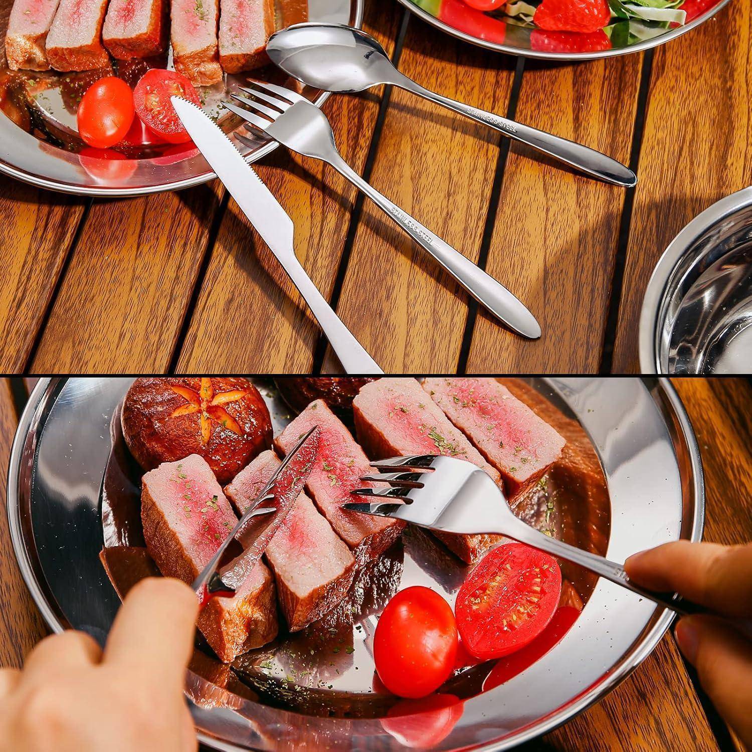 Eine Person schneidet ein medium-rare Steak auf einem Metallteller, begleitet von Tomaten und Grün, und verwendet dabei eine Gabel und ein Messer auf einem Holztisch.