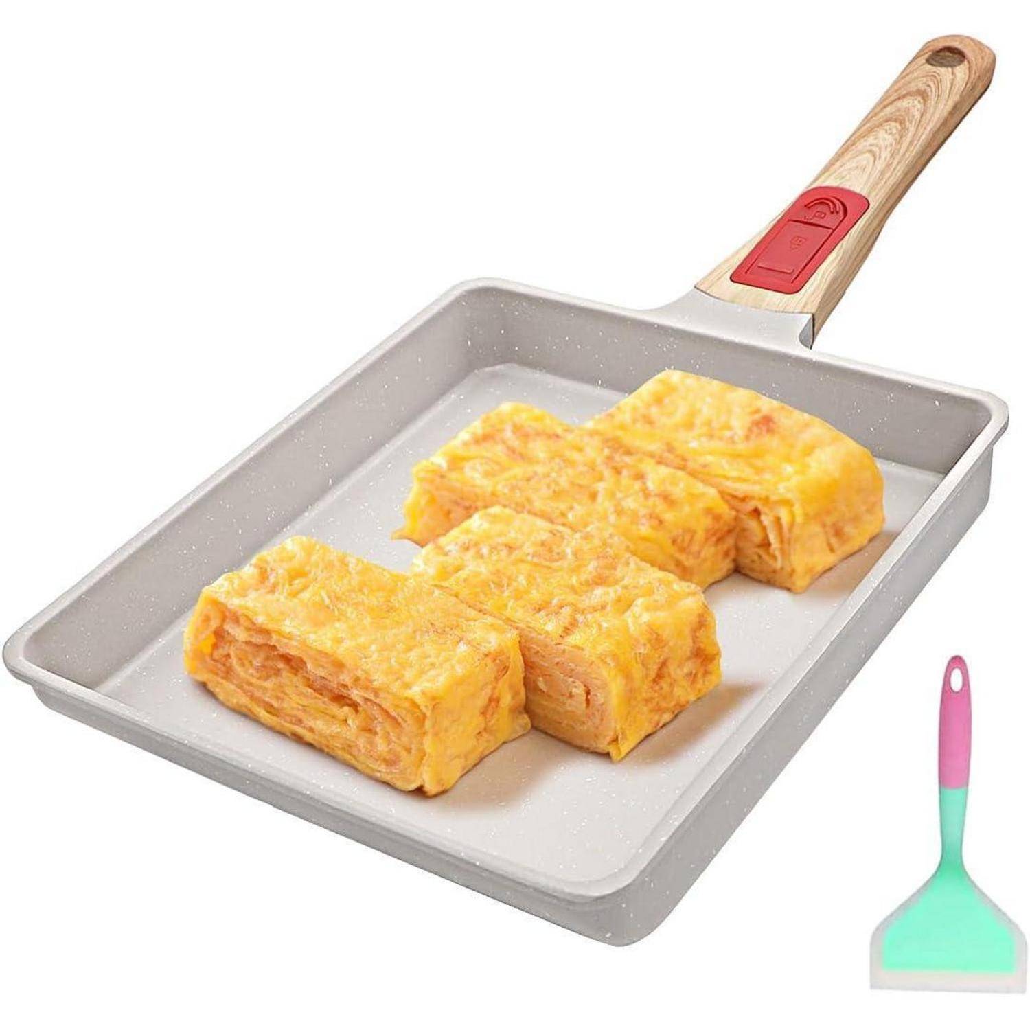 Rechteckige Pfanne mit gebratenen Tamagoyaki-Scheiben (gerolltes Omelett), Holzgriff und kleinem pastellfarbenen Spatel daneben.