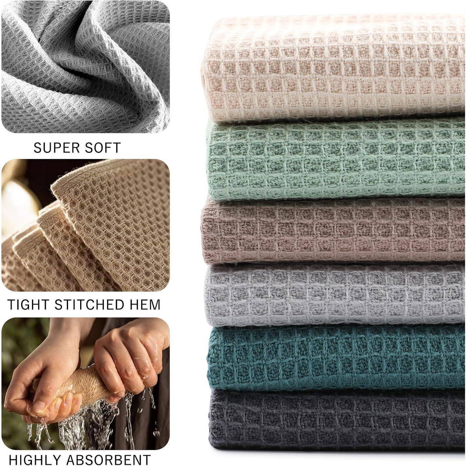 Stapel gefalteter Handtücher in verschiedenen Farben mit Nahaufnahmen, die die 'super weiche' Textur, den 'fest gesteppten Saum' und die 'hohe Saugfähigkeit' zeigen.