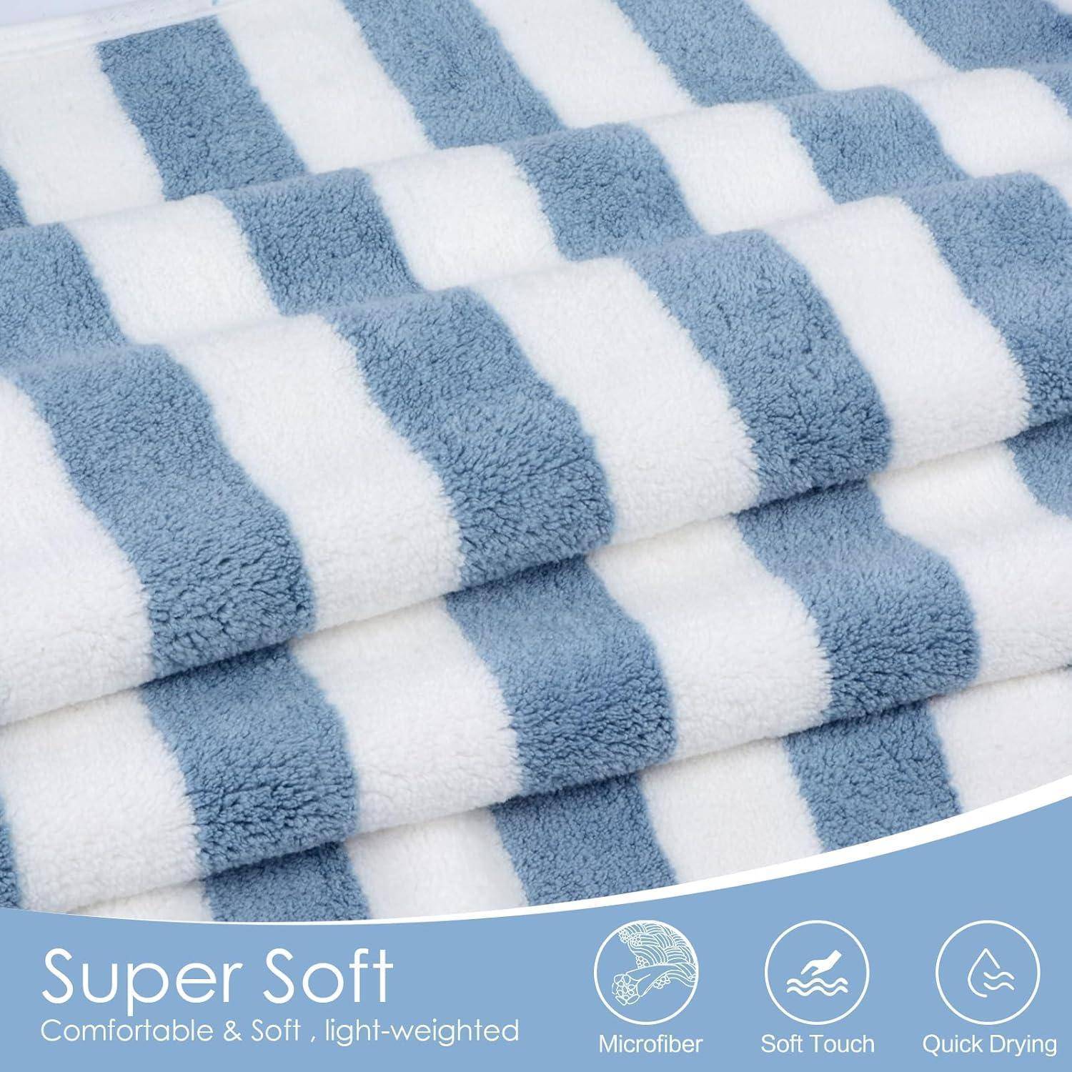 Ein Stapel blau-weiß gestreifter Handtücher mit der Aufschrift ‚Super Soft' und Symbolen, die Mikrofaser, Soft-Touch und schnelle Trocknung anzeigen.