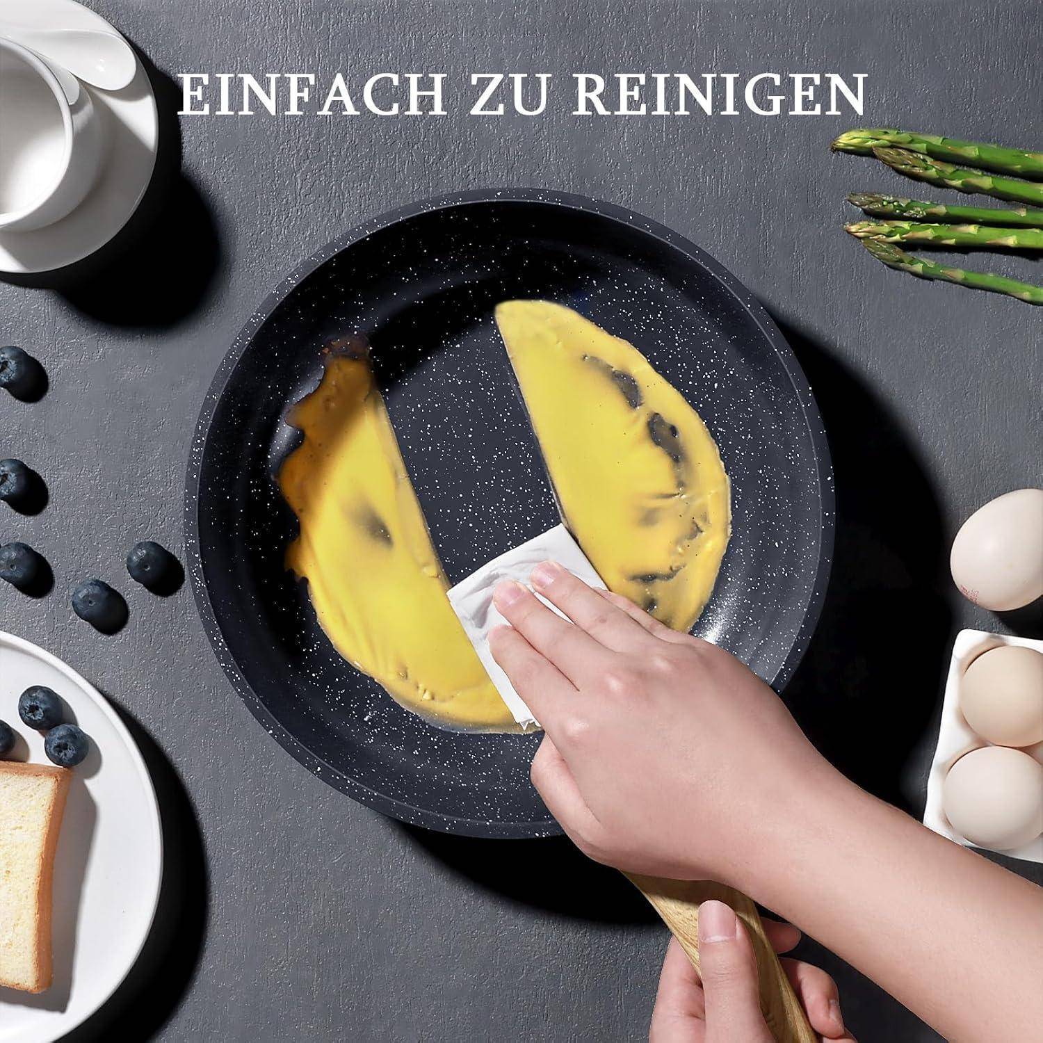 Eine Hand wischt eine Omelett aus einer Antihaftpfanne, umgeben von Eiern, Milch und Gemüse. Text lautet 'EINFACH ZU REINIGEN'.