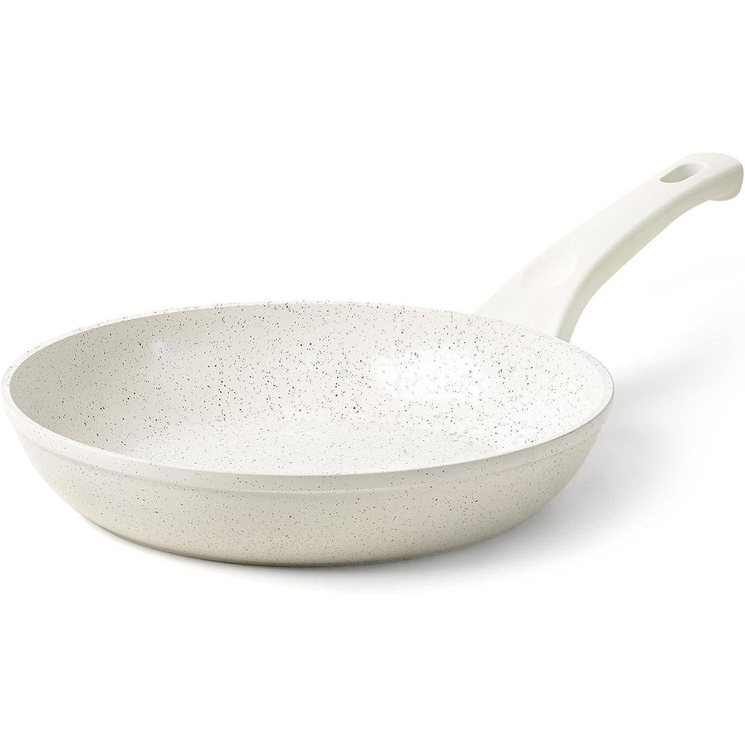 Weiße Pfanne mit gesprenkelter Oberfläche und geschwungenem Griff, für den Küchengebrauch entwickelt.