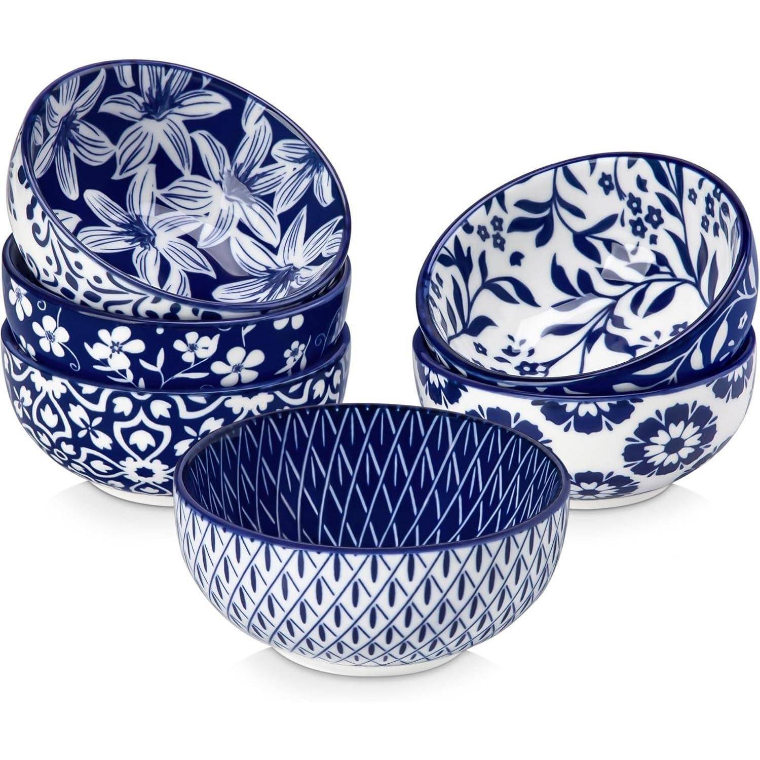 Ein Satz von sechs Keramikschalen, drei Muster: Blumenmotiv, geometrisch und Gitterdesign, alle in Blau und Weiß, ordentlich in zwei Gruppen gestapelt.