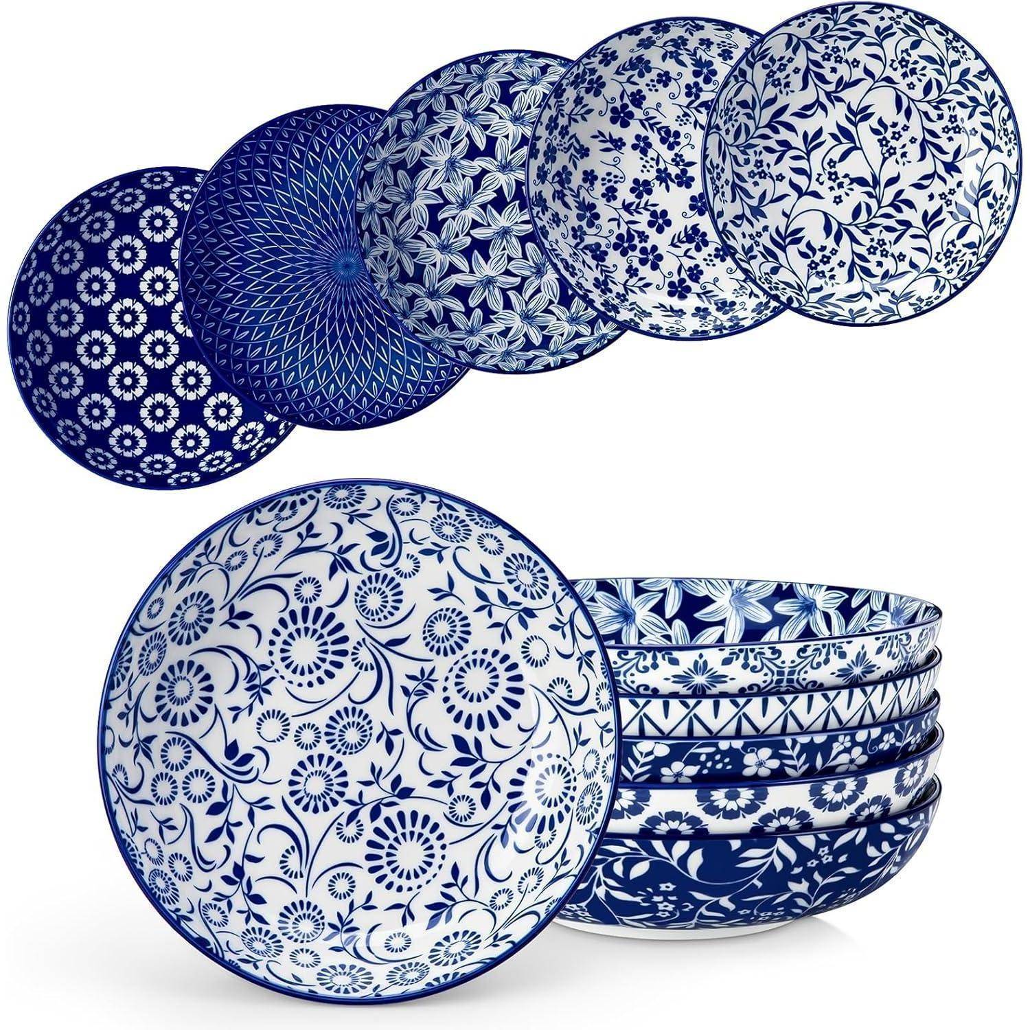 Ein Satz blau-weißer, gemusterter Keramikschalen, von denen jede ein einzigartiges Blumen- oder geometrisches Muster trägt, säuberlich aufgestapelt.