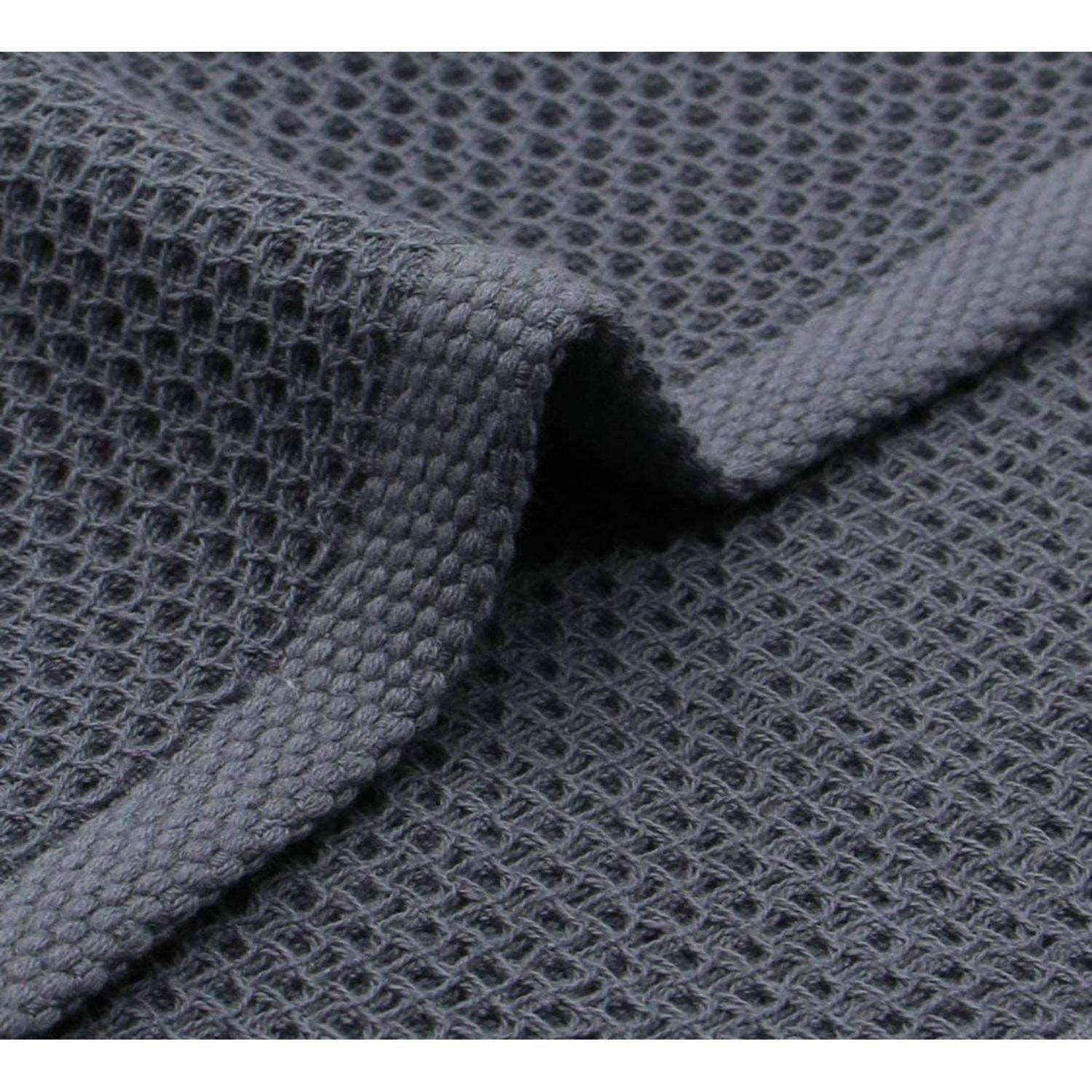 Nahaufnahme eines grauen Gewebes mit Waffelmuster. Der Stoff ist leicht gefaltet und zeigt seine Dicke und Textur.