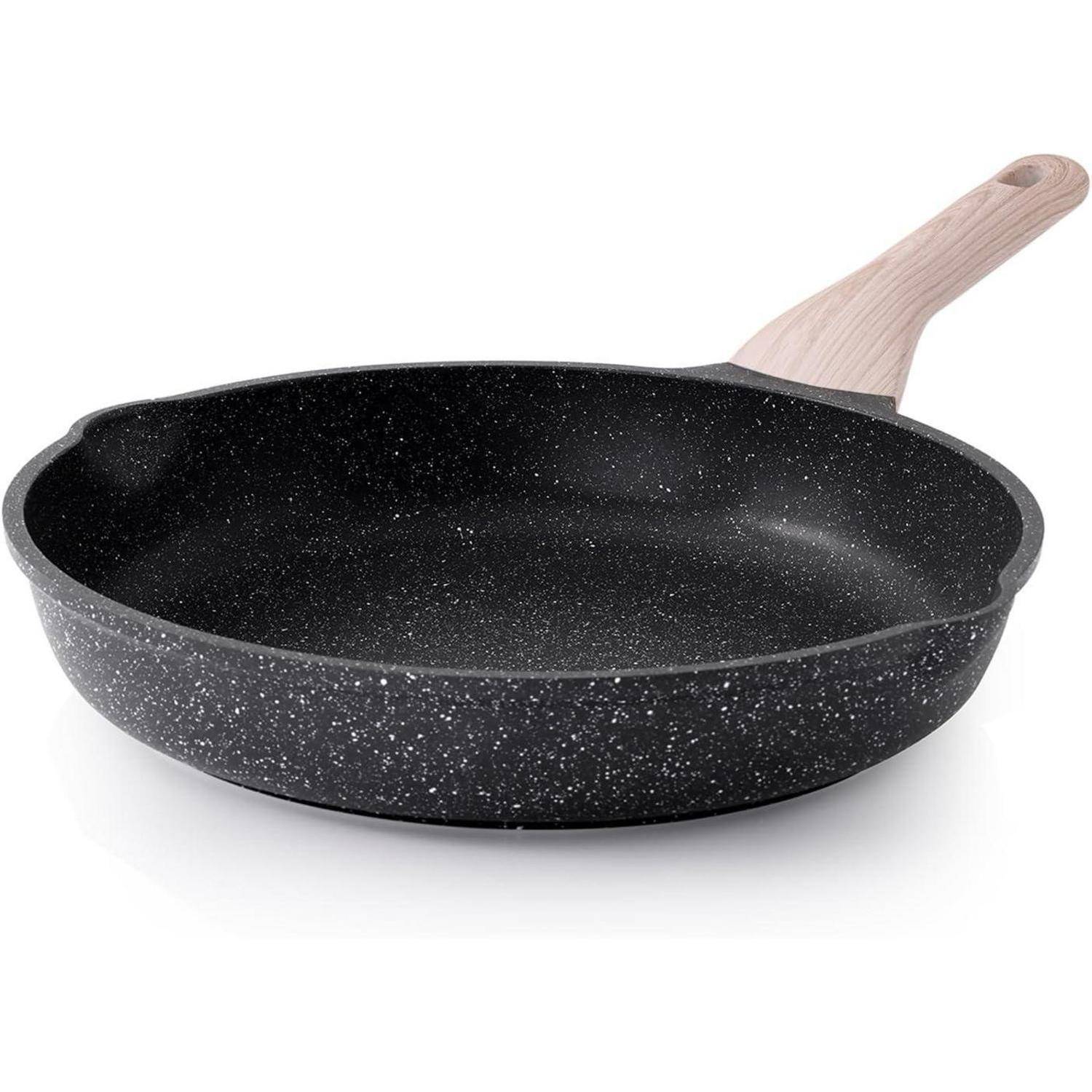 Eine schwarze Antihaft-Bratpfanne mit einem gesprenkelten Muster und einem hellen Holzgriff, die vor einem einfarbigen weißen Hintergrund platziert ist.