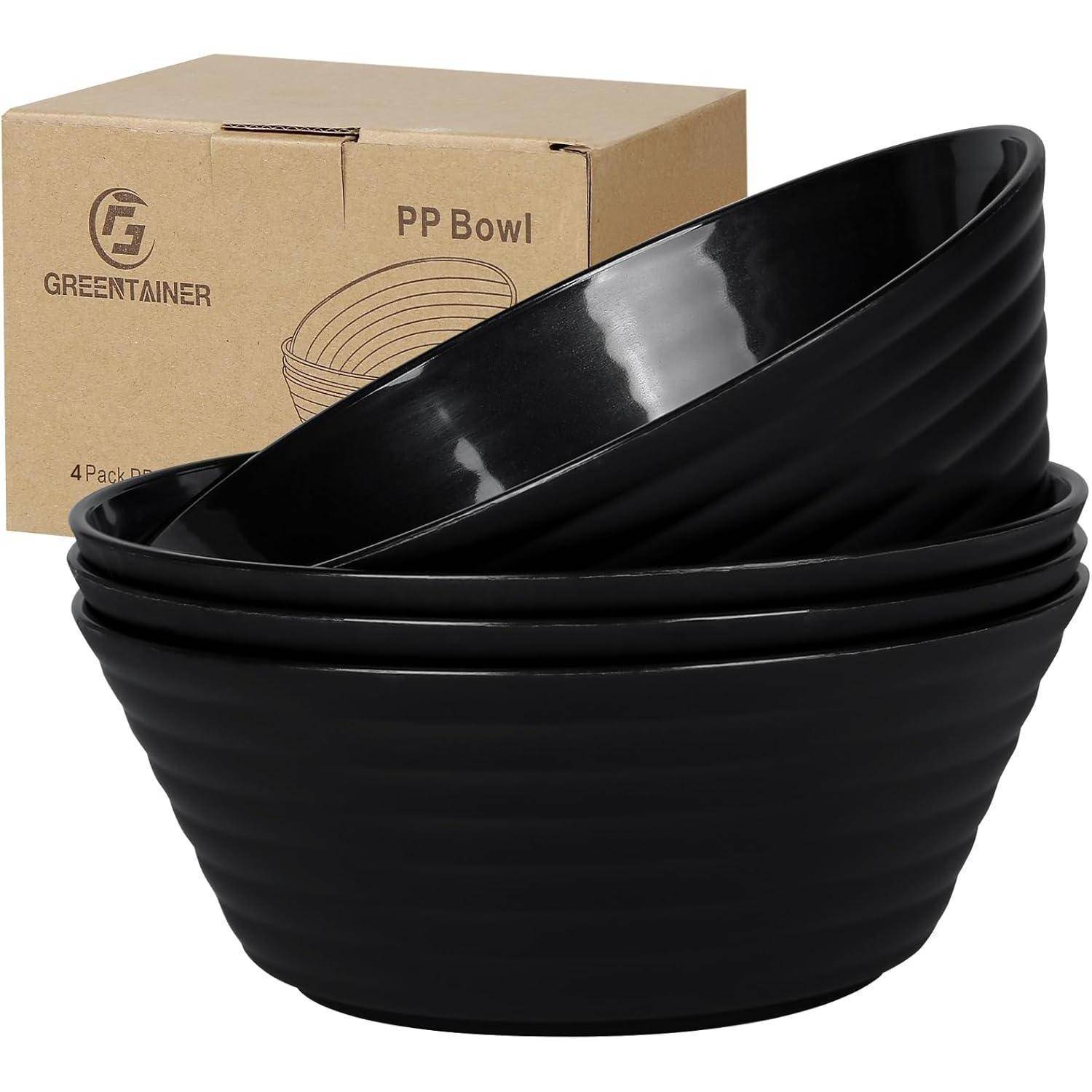 Ein Satz von vier schwarzen Plastikschüsseln, die ineinander gestapelt sind, mit einer Pappschachtel, die mit 'PP Bowl' und 'GREENTAINER' beschriftet ist, im Hintergrund.