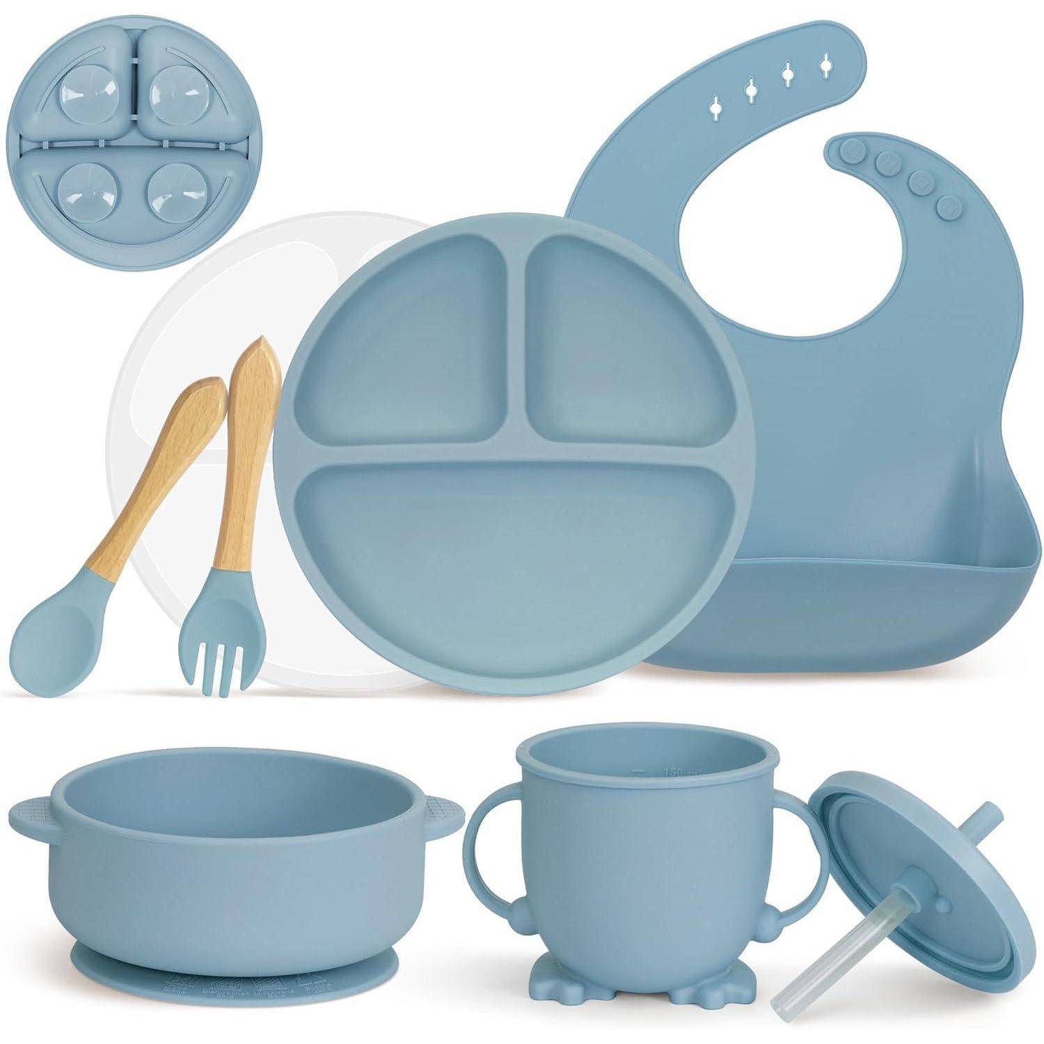 Ein Set aus blauen Silikon-Babyernährungsartikeln, bestehend aus einem Lätzchen, einem geteilten Teller, einer Schüssel, einer Tasse, Besteck und einem Deckel mit Strohhalmlöchern.