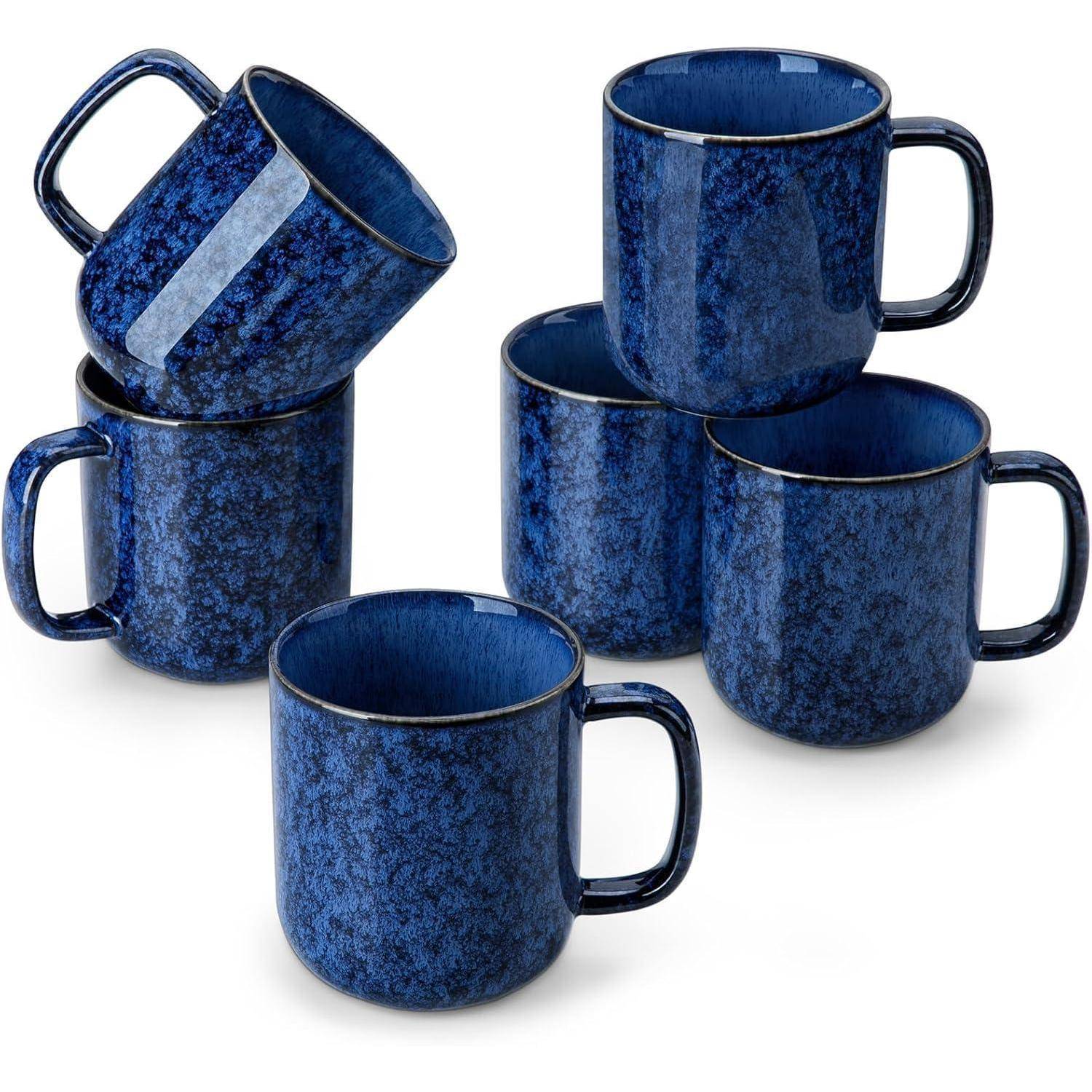 Ein Set aus fünf blauen Keramiktassen mit einer strukturierten, getupften Gestaltung. Vier Tassen sind gestapelt und eine ist geneigt, wodurch ihr einzigartiges Muster zur Geltung kommt.