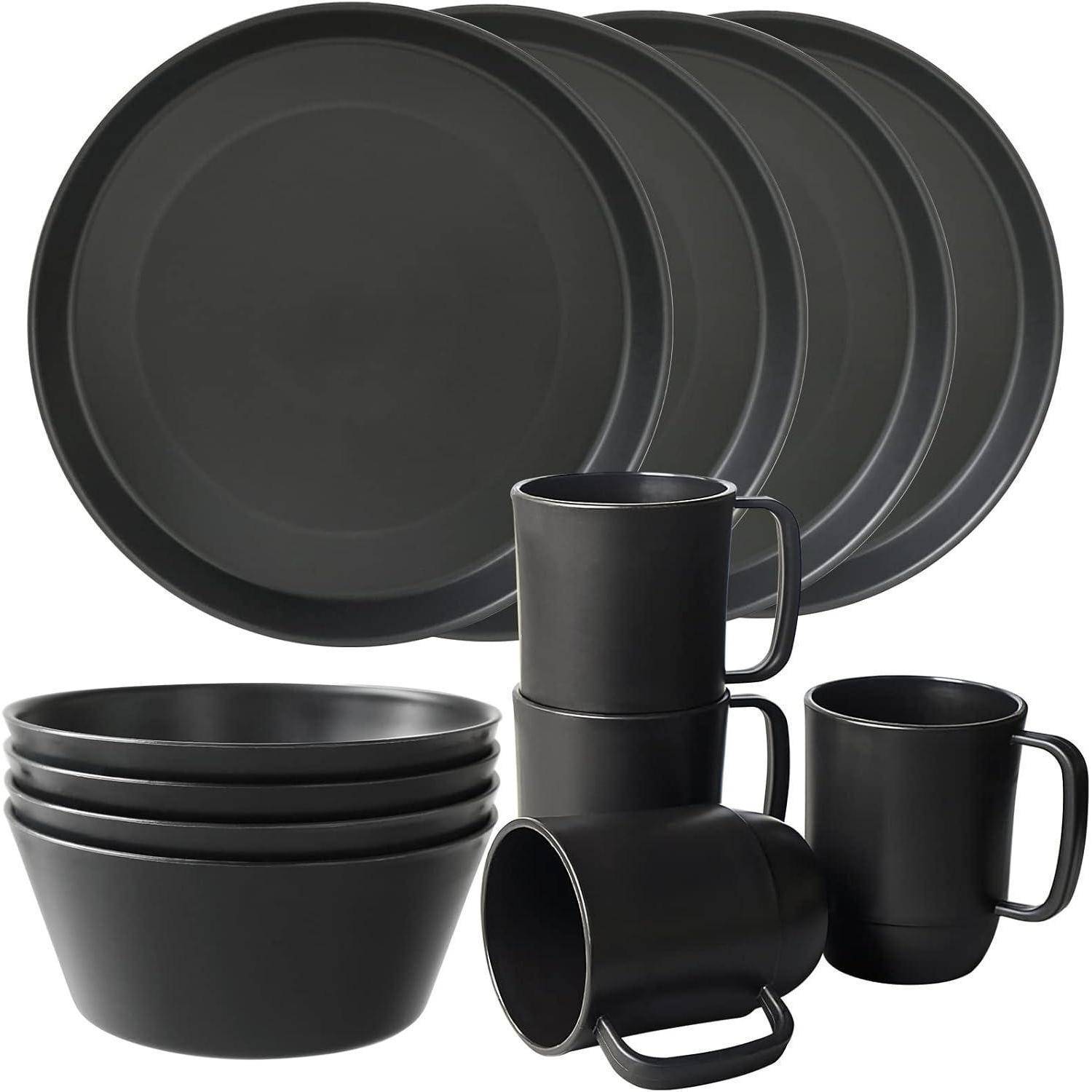 Ein schwarzes Geschirrset umfasst vier Teller, vier Schüsseln und vier Tassen, alle einheitlich gefärbt für einen modernen, minimalistischen Look.
