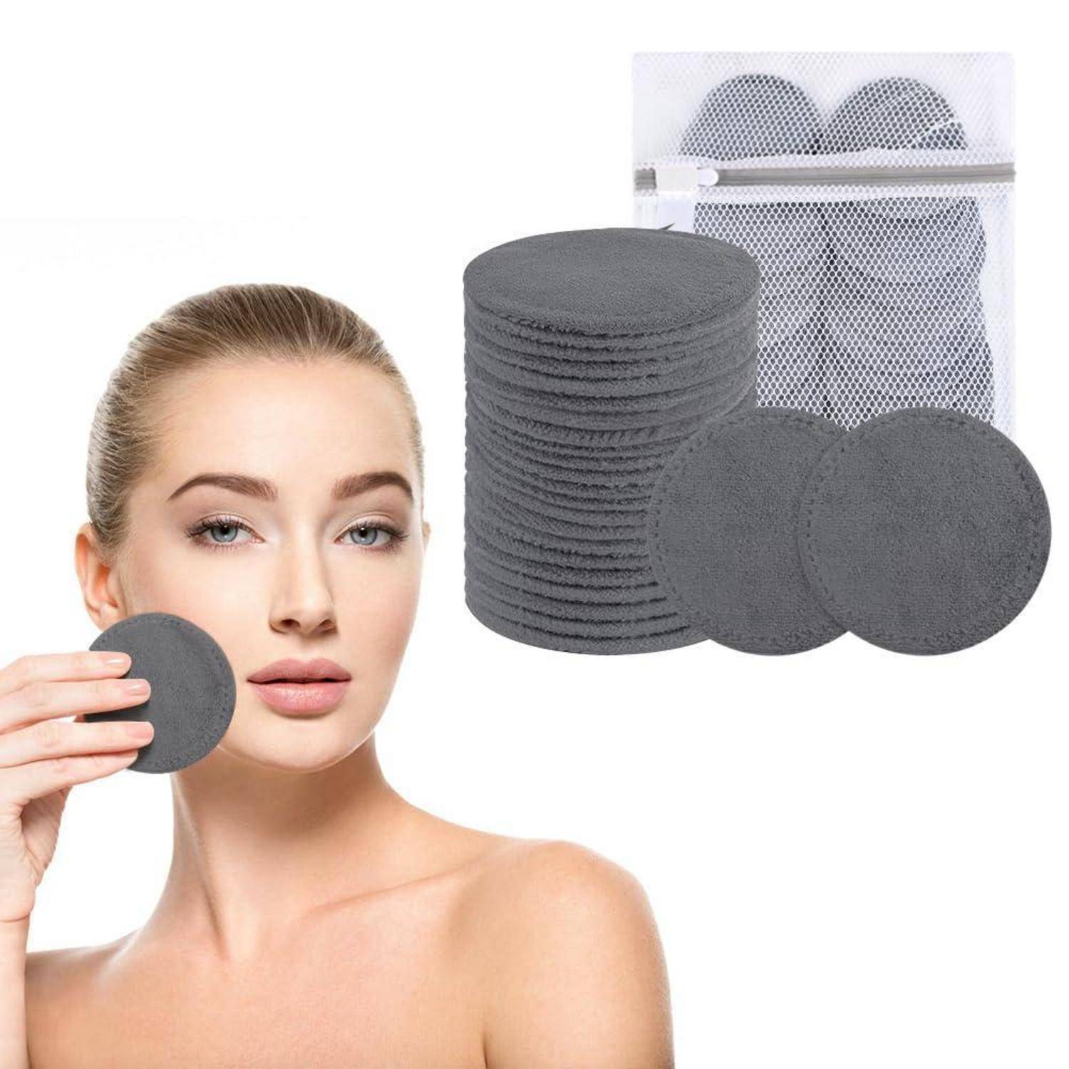 Eine Frau hält ein graues wiederverwendbares Make-up-Entfernungspad neben ihrem Gesicht. Ein Stapel ähnlicher Pads und ein Netzbeutel zur Aufbewahrung sind neben ihr zu sehen.