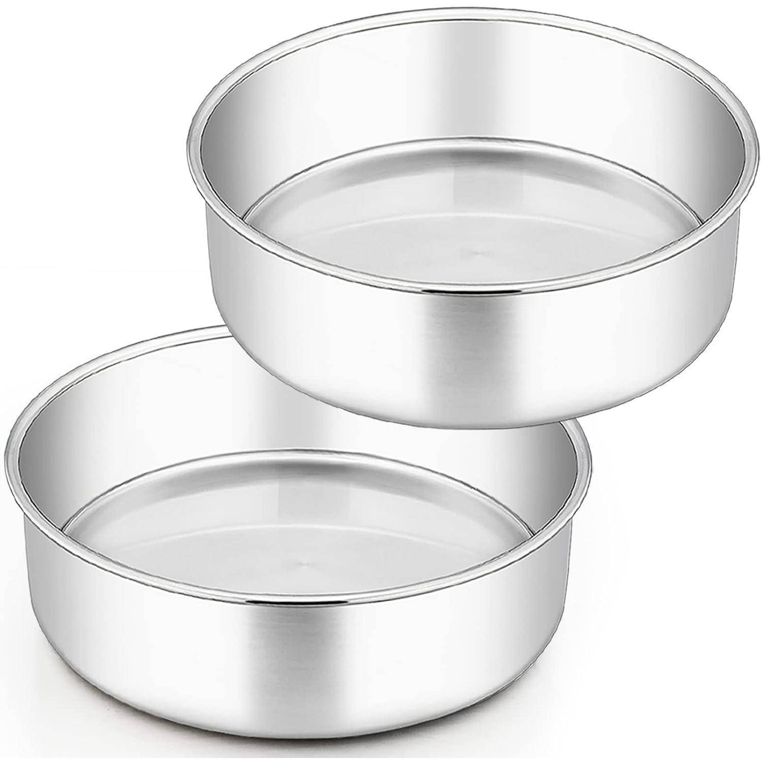 Zwei runde, glänzende Metalbackformen, leicht versetzt übereinander gestapelt, die ihre Tiefe und glatte Oberfläche zeigen, geeignet zum Kochen oder Backen.