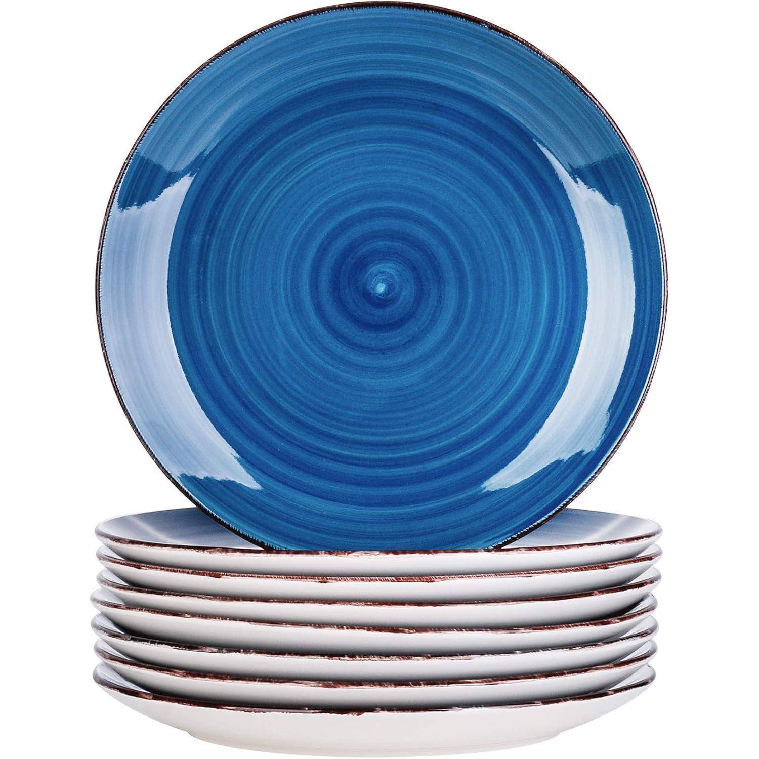 Ein Stapel von sieben Keramiktellern, sechs weiß mit einem blauen Rand, und ein blauer Teller mit einem Spiralmuster obenauf.