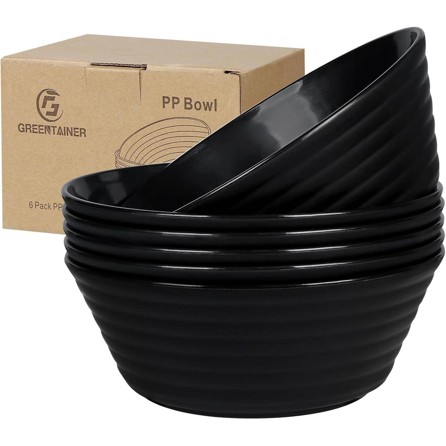 Ein Stapel aus fünf schwarzen Schalen vor einem Pappkarton mit der Aufschrift „Greentainer PP Bowl