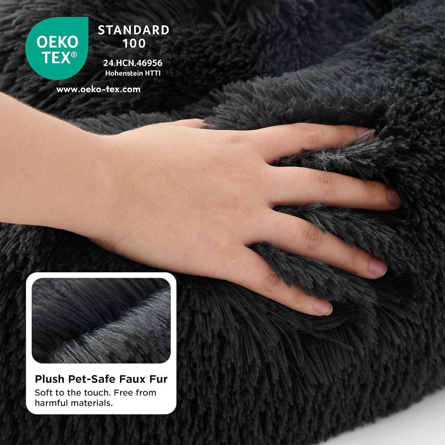 Eine Hand berührt weichen, dunkelgrauen Plüsch aus tierfreundlichem Kunstfell, das nach OEKO-TEX Standard 100 als frei von schädlichen Materialien zertifiziert ist.