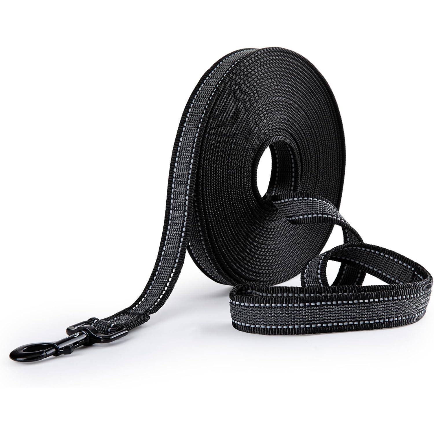 Eine aufgewickelte, schwarze Hundeleine mit reflektierender Naht und einem Metallkarabiner, geeignet für Spaziergänge mit Haustieren im Freien, vor einem einfarbigen Hintergrund.