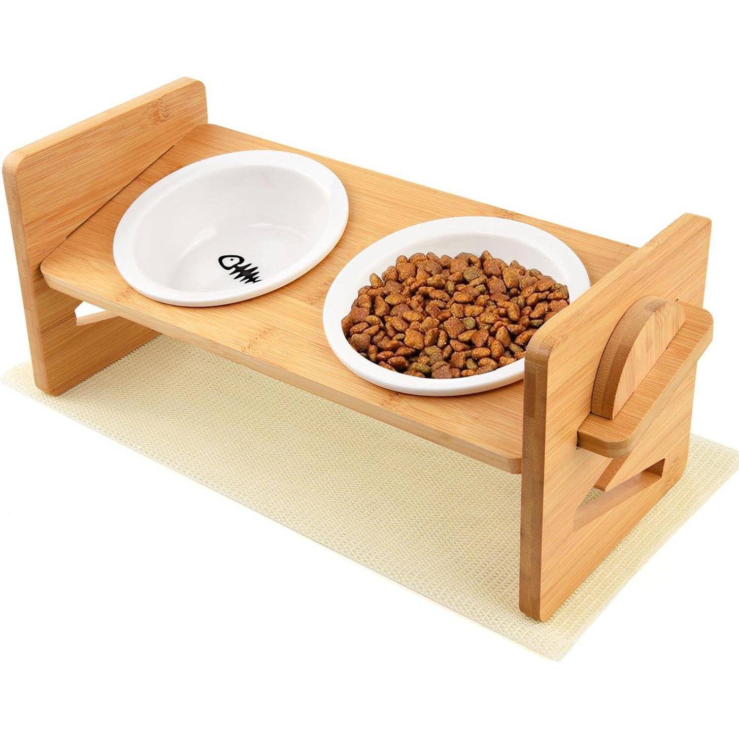 Erhöhter Holz-Futternapf mit zwei Schüsseln; eine leer und eine gefüllt mit Trockenfutter, auf einer hellfarbenen Matte platziert.