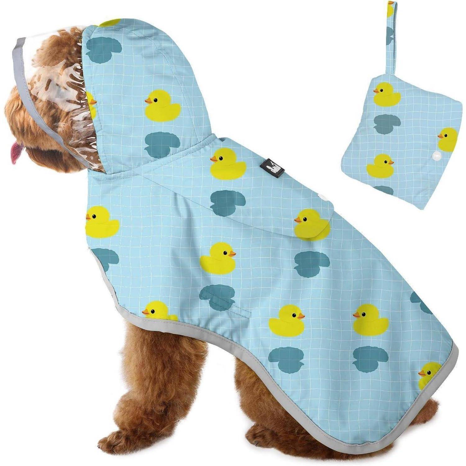 Ein Hund trägt einen blauen Regenmantel mit gelben Entenabdrücken. Der Regenmantel verfügt über eine Kapuze, und eine passende Tasche ist daneben zu sehen.