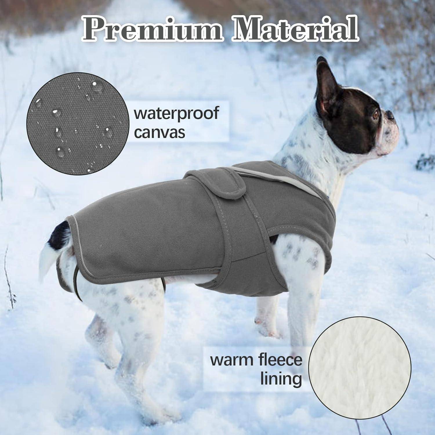 Ein Hund mit einer grauen Jacke steht im Schnee. Der Text liest sich als 'Premium Material' und hebt 'wasserdichtes Segeltuch' und 'warme Fleecefütterung' hervor.