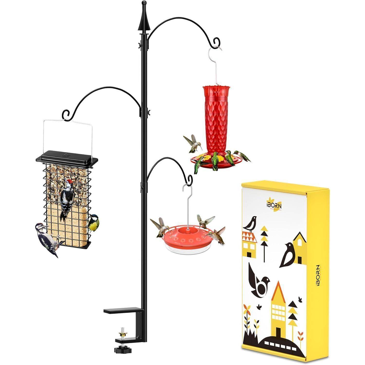 Eine Vogelfuttersäule mit drei Arten von Futterplätzen: einem Samenkorb, einem roten Flüssigkeitsfutterer und einer flachen Schale, umgeben von Vögeln. Gelbe Box inklusive.