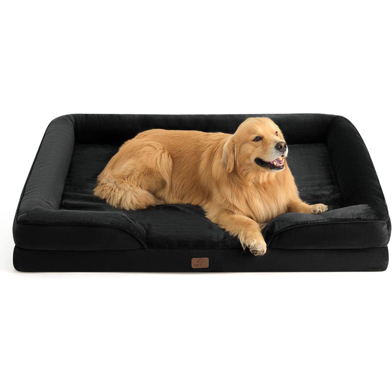 Ein Golden Retriever liegt gemütlich auf einem schwarzen, gepolsterten Hundebett mit erhöhten Kanten.
