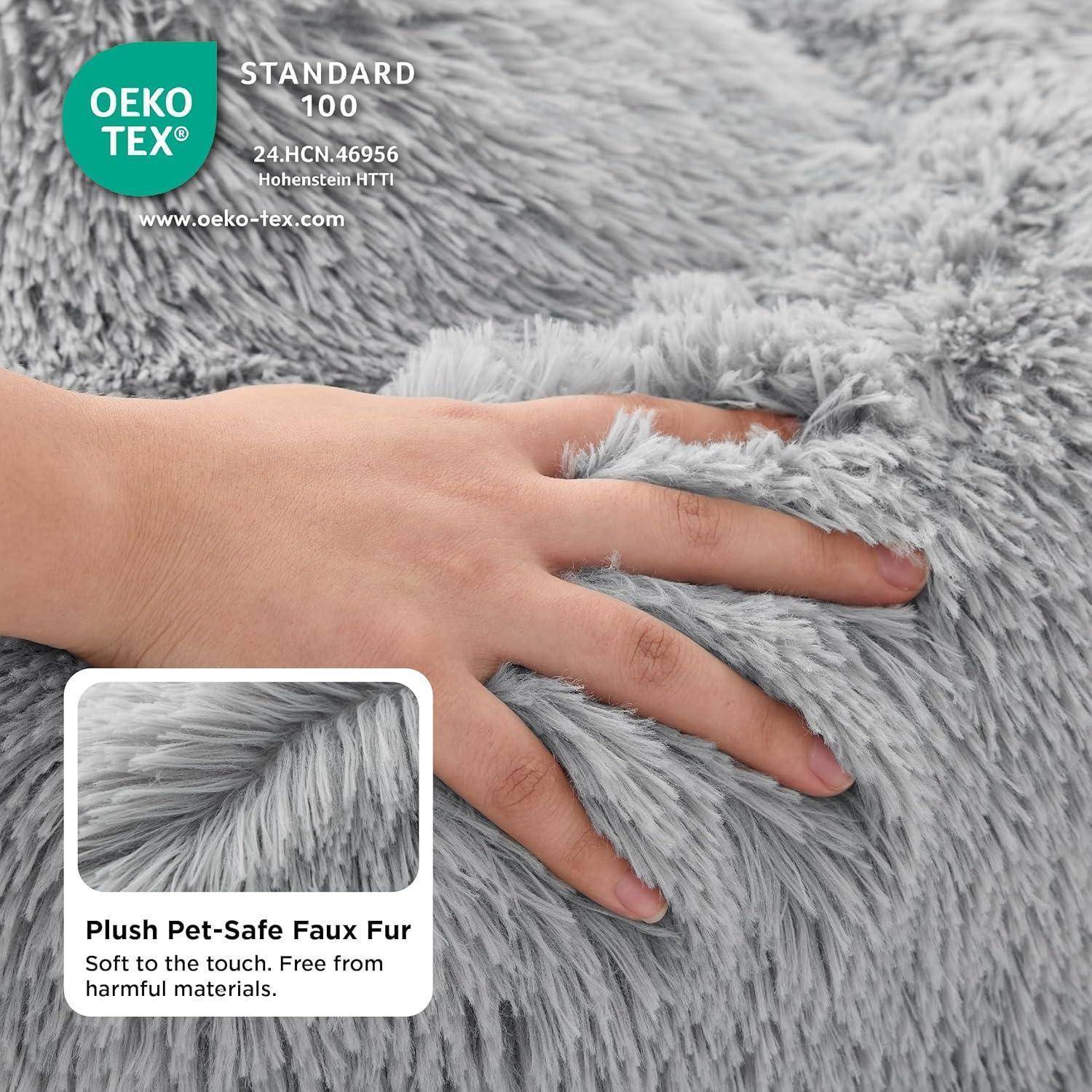 Plüschiges, haustiersicheres Kunstfell. Weich beim Anfassen. Frei von schädlichen Materialien.' Eine Hand berührt weiches, graues Kunstfell mit Oeko-Tex-Zertifizierung.