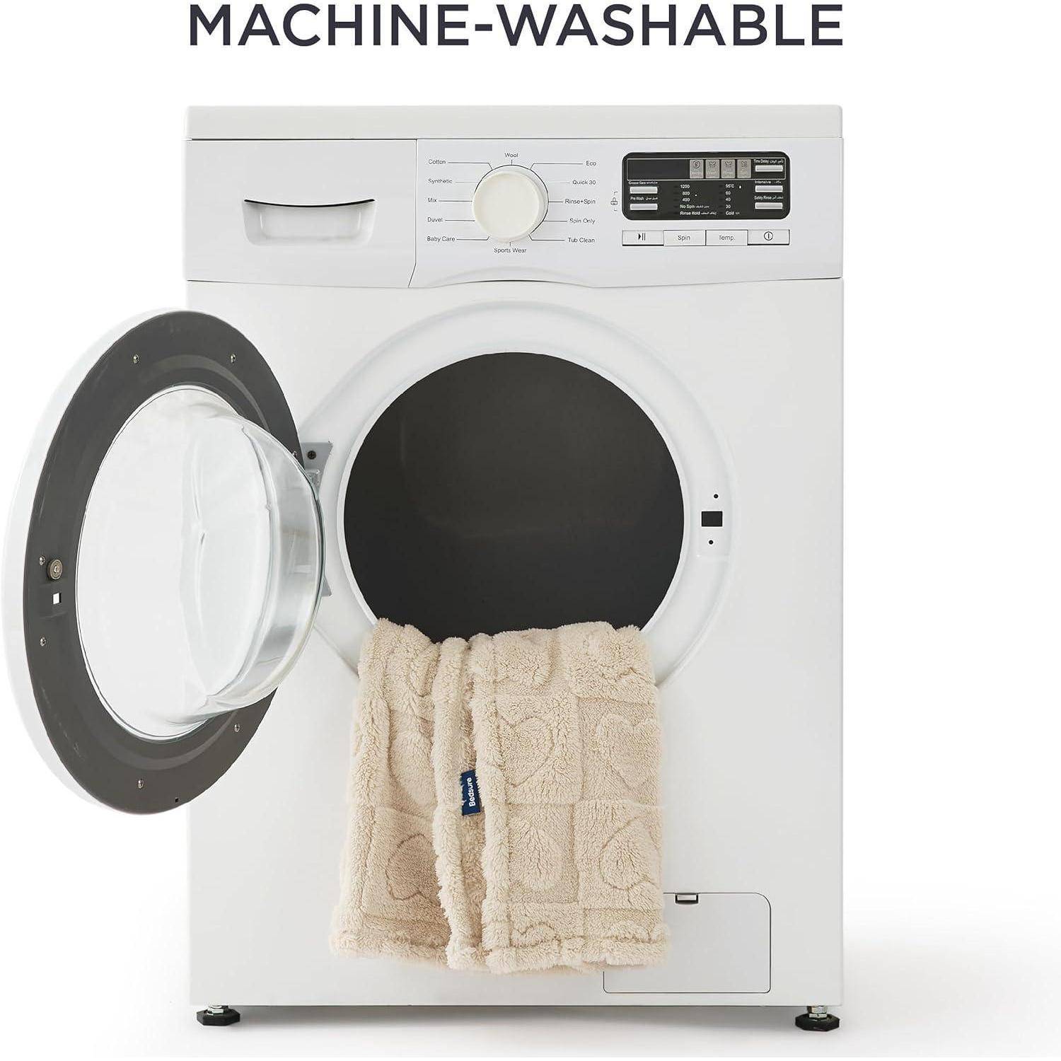 Waschmaschine mit offener Tür, in der ein beige Handtuch teilweise zu sehen ist. Das Etikett 