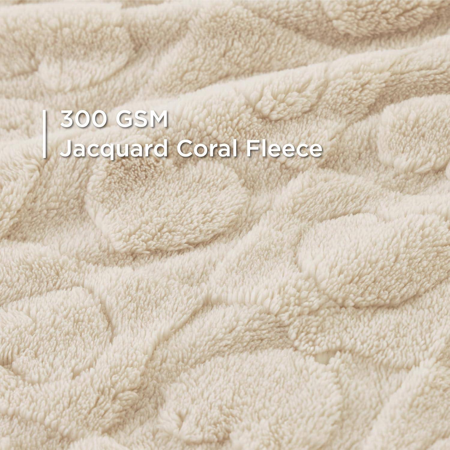 „Nahaufnahme eines weichen, strukturierten Gewebes mit der Aufschrift ‚300 GSM Jacquard Korall-Fleece', die detaillierte gewebte Muster zeigt.