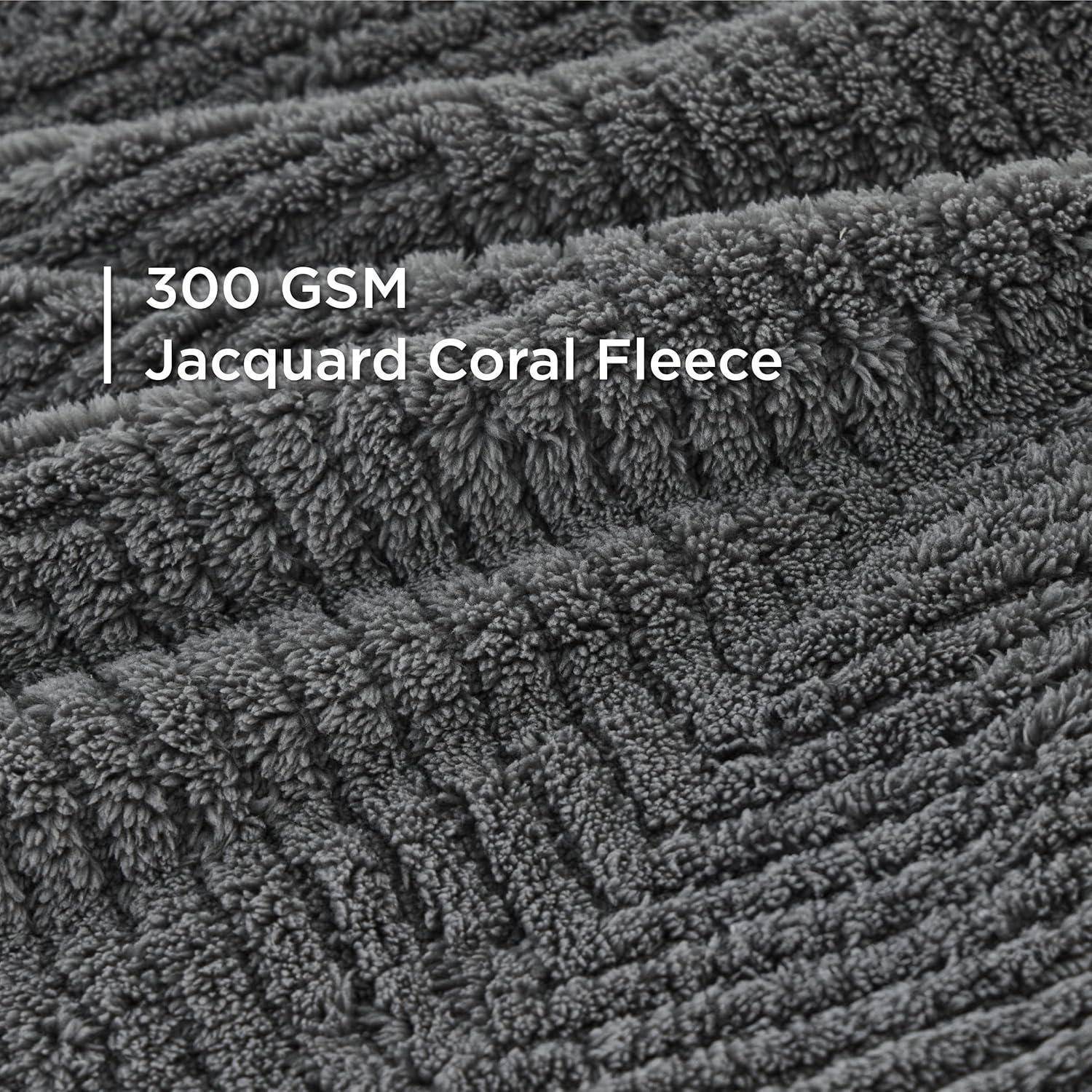 Nahaufnahme von 300 GSM Jacquard Korallenfleece, die den dicken, strukturierten Stoff in Dunkelgrau mit einer plüschigen, gemusterten Oberfläche zeigt.