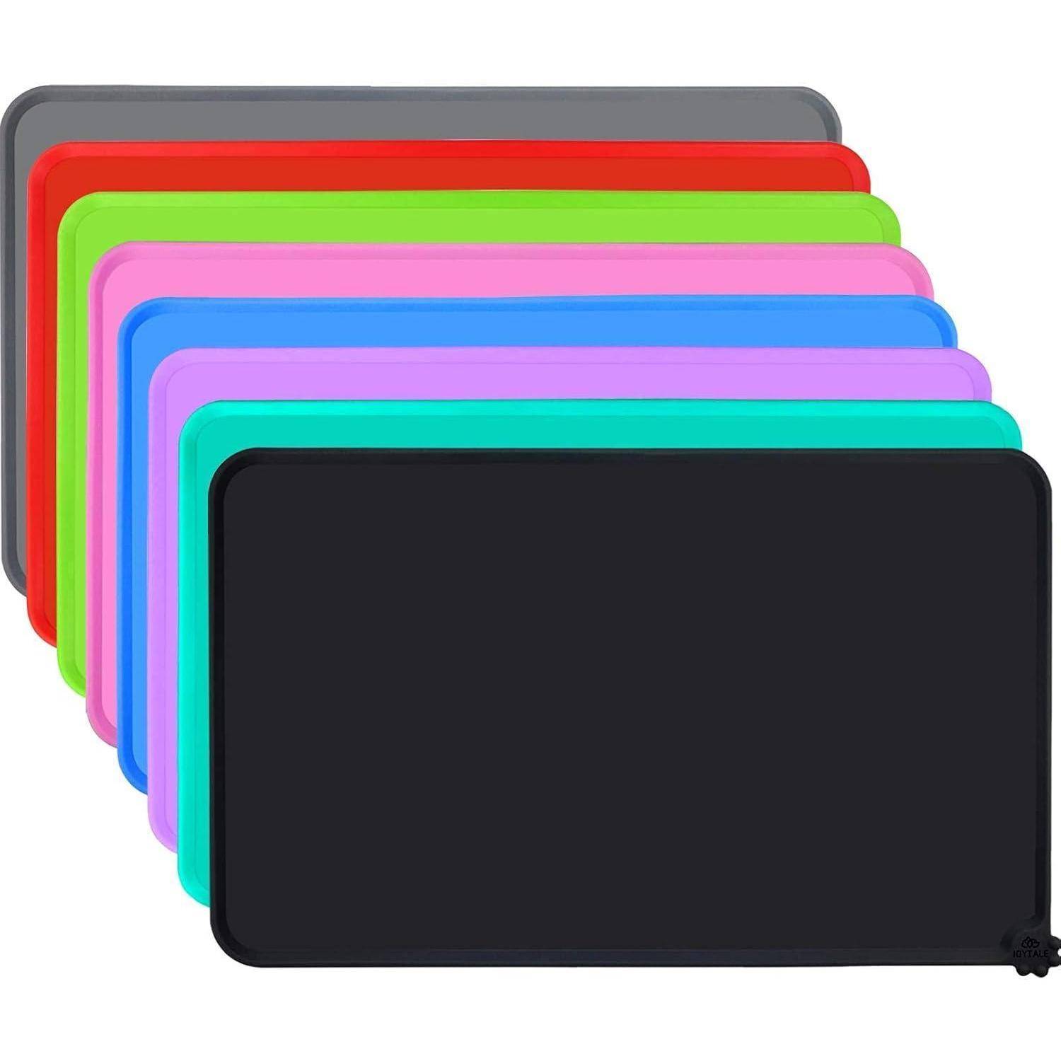Ein Stapel bunter, rechteckiger Schneidebretter, leicht aufgefächert. Die Farben umfassen Schwarz, Petrol, Lila, Blau, Rosa, Rot, Grün und Grau.