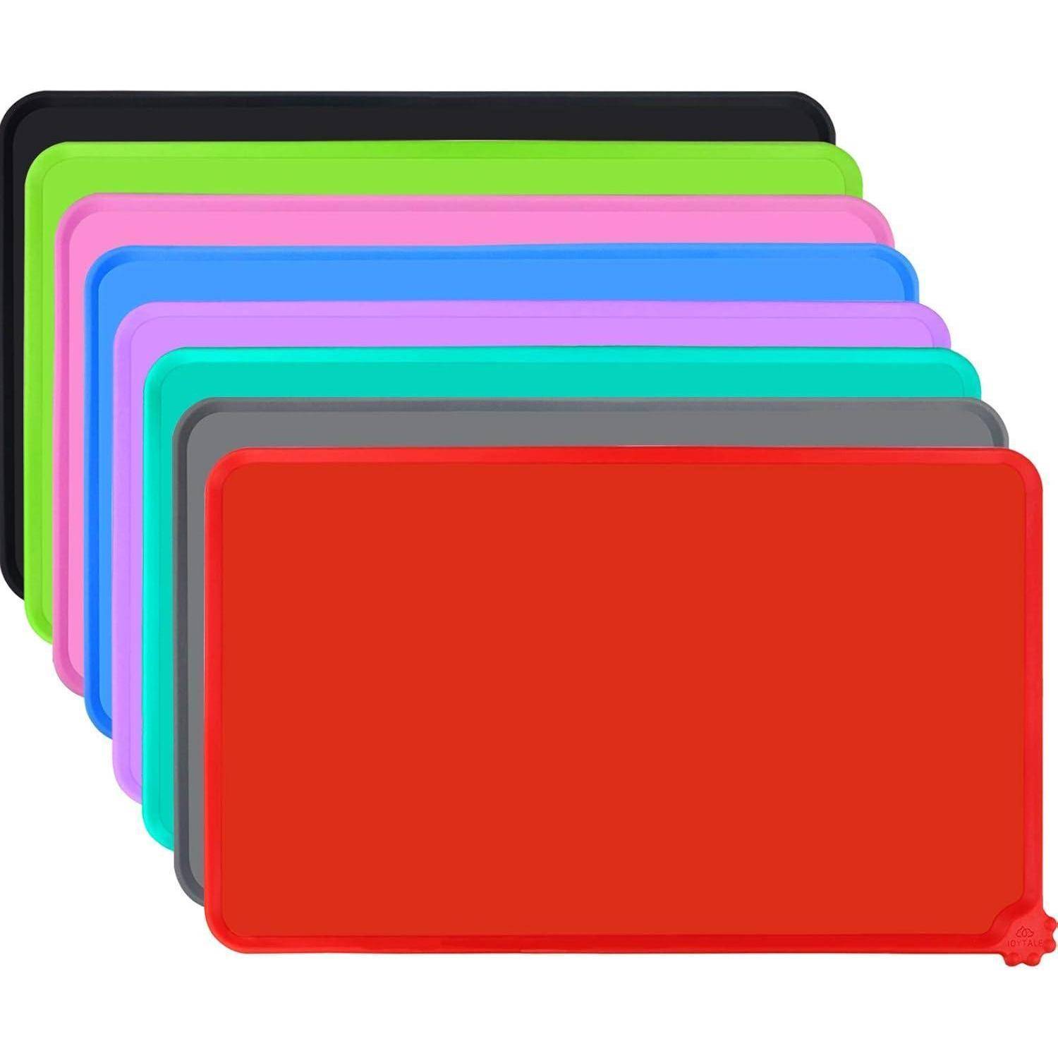 Ein Stapel bunter rechteckiger Schneidbretter in verschiedenen Farben: Schwarz, Hellgrün, Blau, Magenta, Grau und Rot obenauf.
