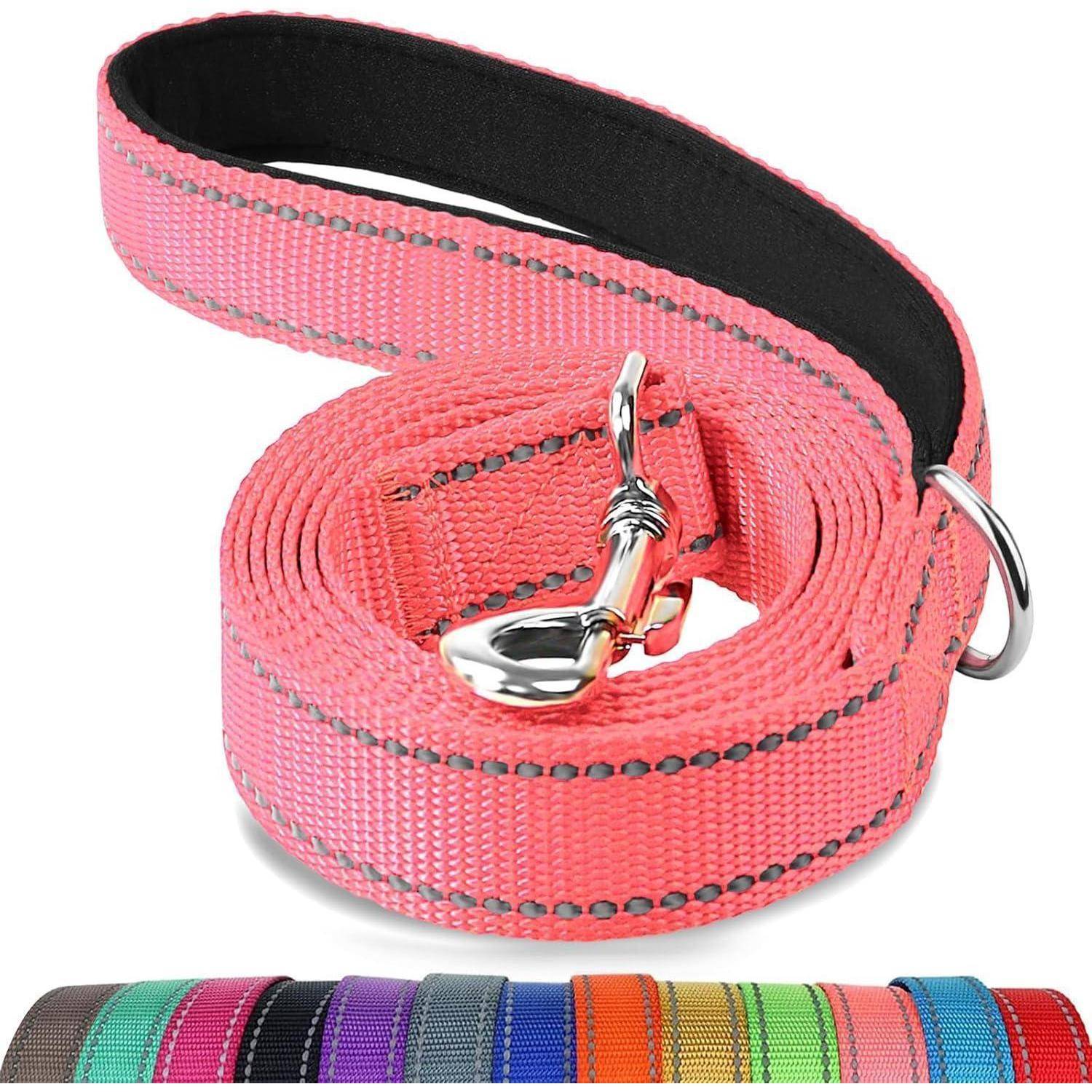 Eine rosa reflektierende Hundeleine mit einer Metallklemme, ordentlich aufgerollt. Darunter sind mehrere Leinen in verschiedenen Farben in einer Reihe ausgestellt.
