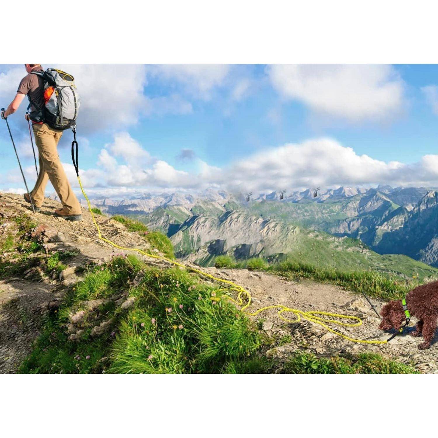 Ein Wanderer geht einen Bergpfad entlang mit Blick auf weite, felsige Gipfel unter einem strahlend blauen Himmel. Ein Seil und ein Stofftier liegen auf dem Boden.