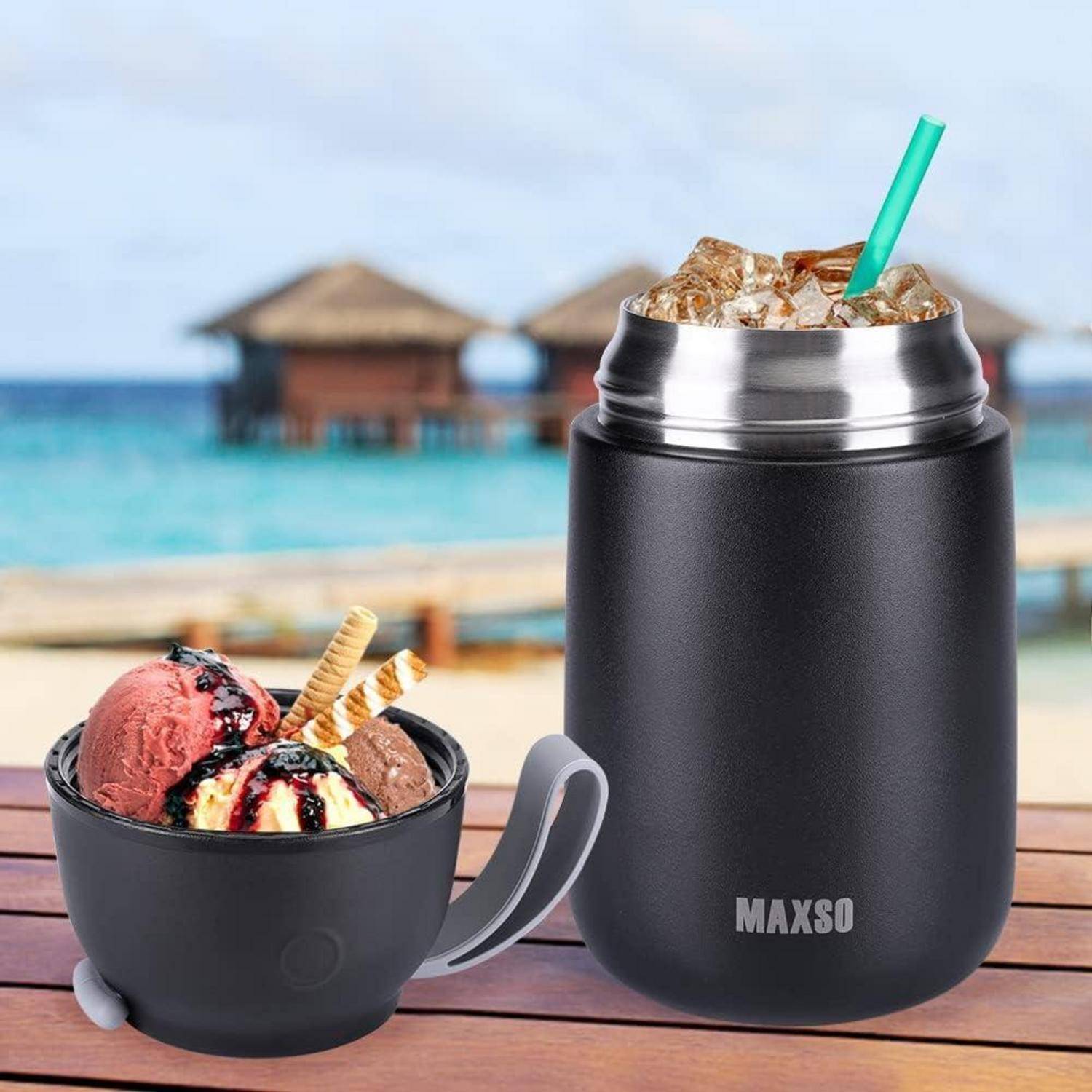 Ein schwarzer isolierter Behälter mit einem Metalldeckel enthält Eiskaffee mit einem Strohhalm, der neben einer Eisportionierer-Schüssel an einem tropischen Strand platziert ist.