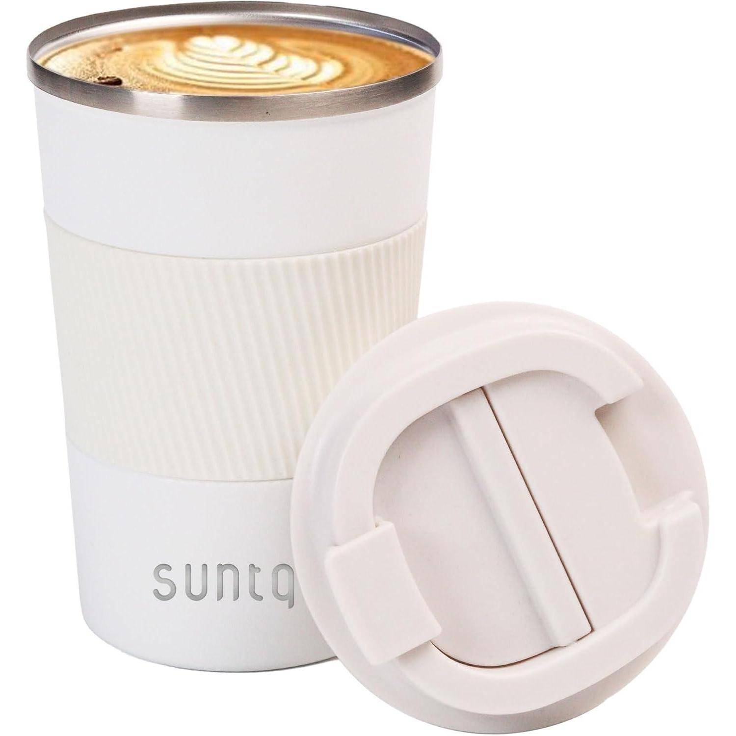 Eine weiße isolierte Kaffeetasse gefüllt mit einem Latte, mit einem gewellten Design und dem Text 'suntq' nahe dem Boden. Der Deckel liegt daneben.